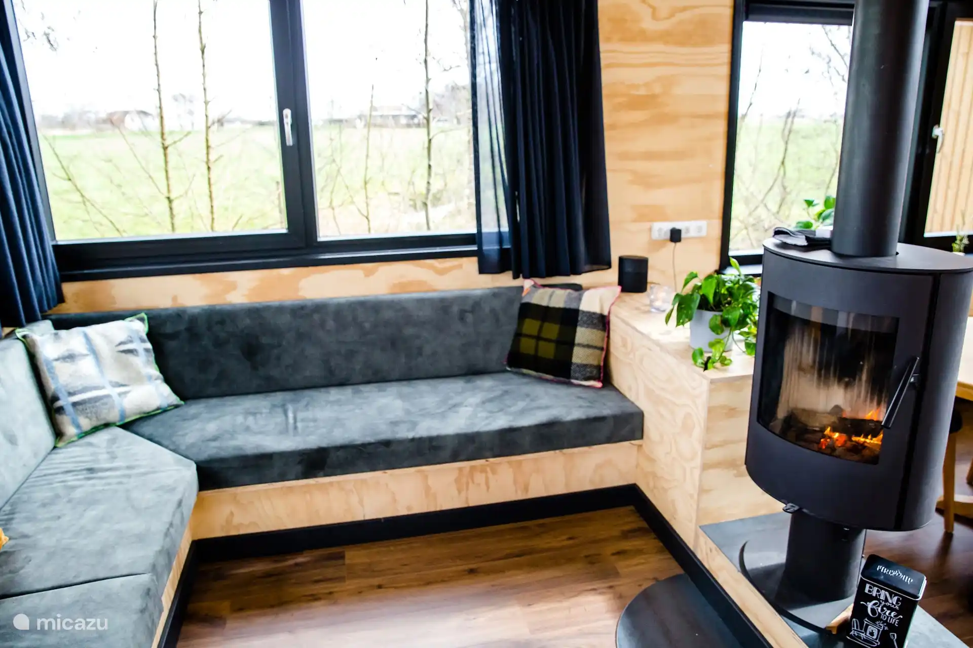 Woonkamer met houtkachel en comfortabele zithoek.