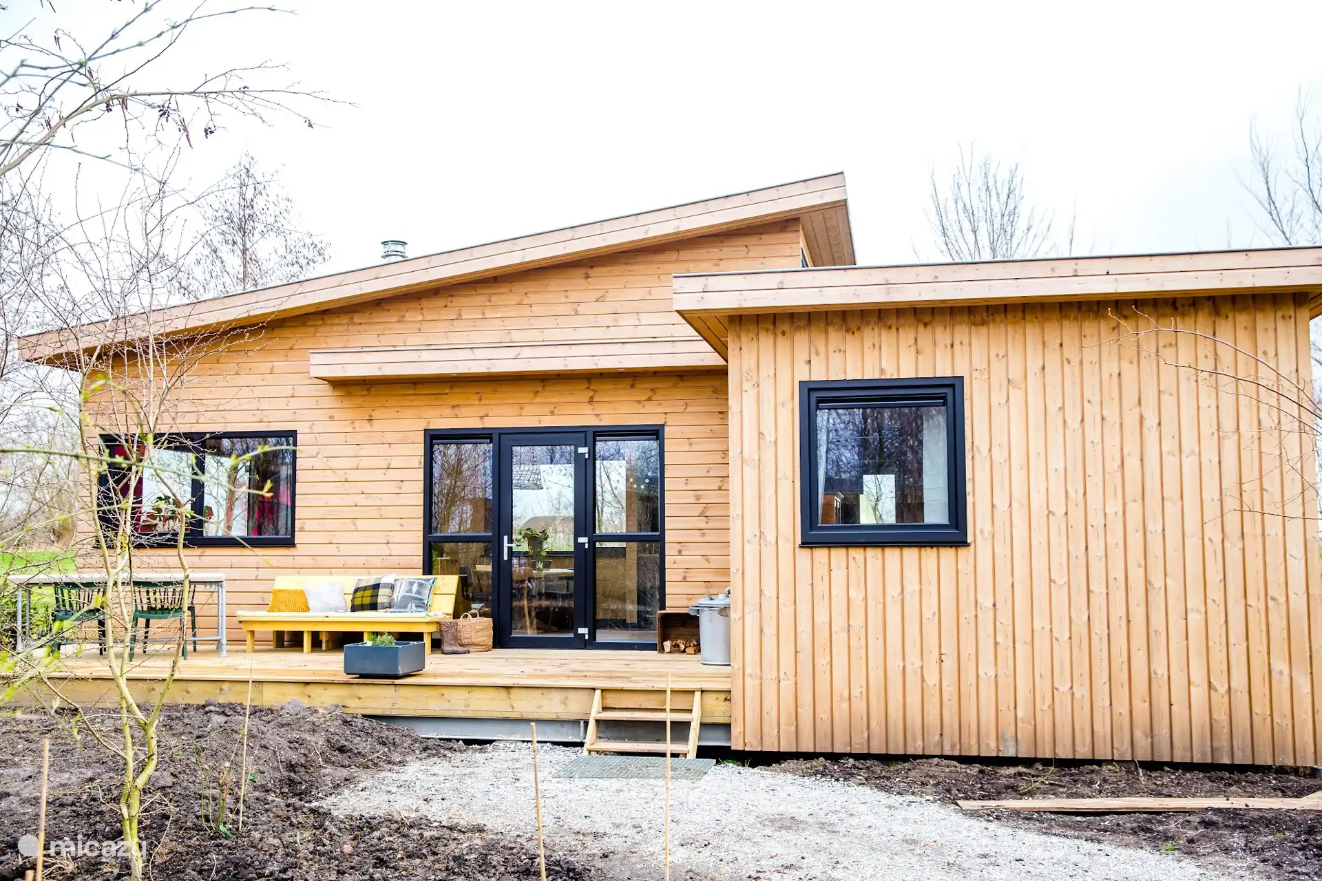 De lodge gezien vanaf de tuin, tussen het groen.