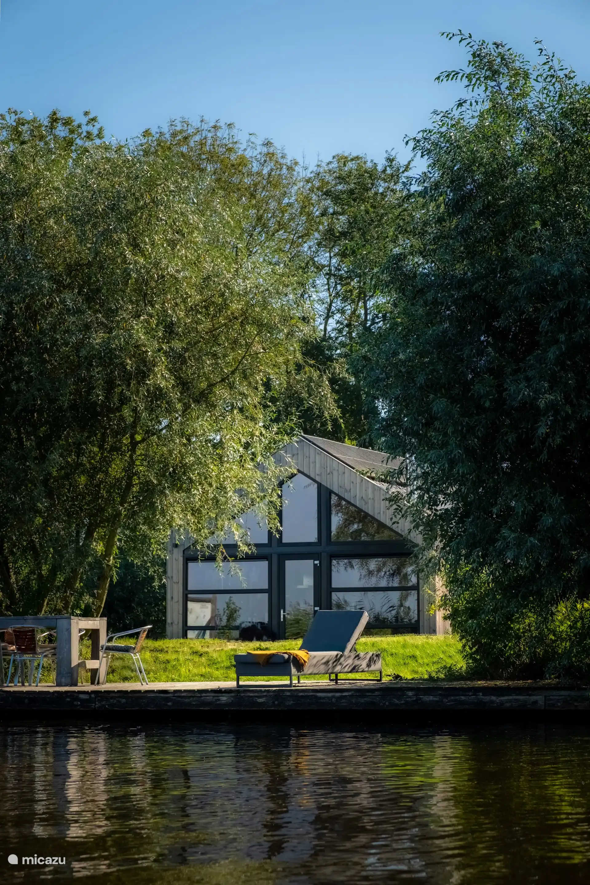 Waterlodge Reidhintsje vanuit de tuin, weggedoken tussen het groen.