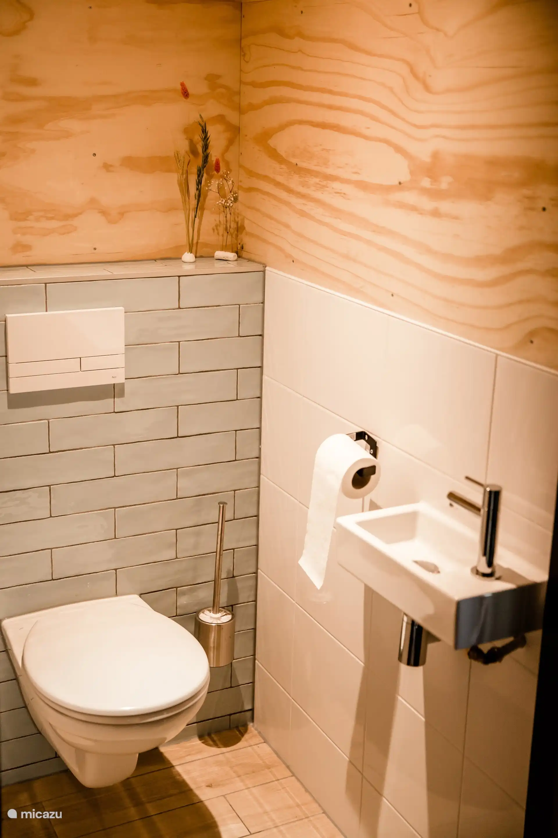 Toilet met wastafel, sfeervol afgewerkt met houten wanden.