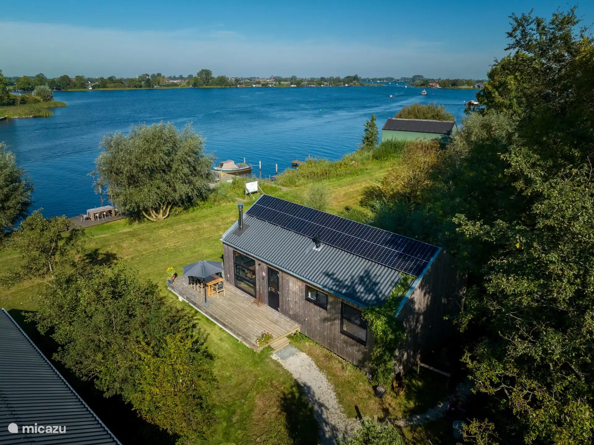 Luchtfoto van Waterlodge Reidhintsje aan het water, omringd door groen.