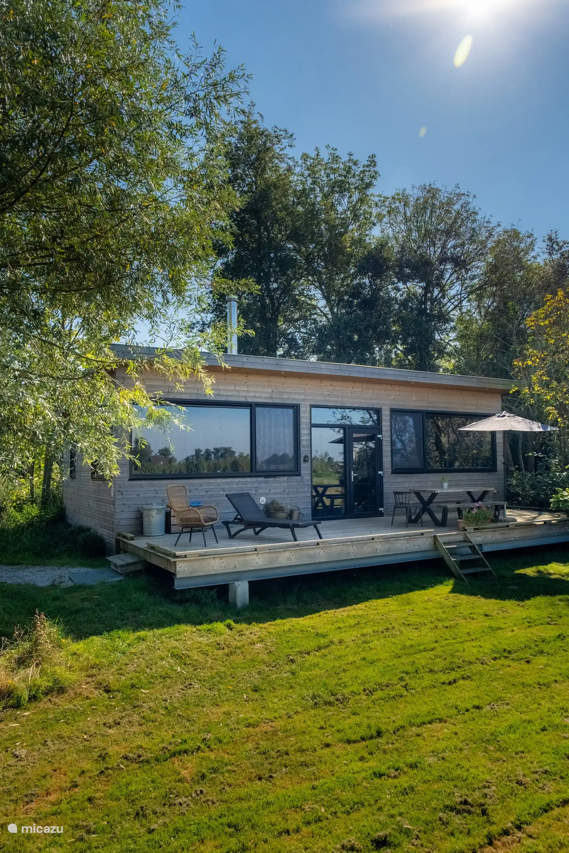 Waterlodge Reidsjonger vanuit de tuin, tussen het groen van het park.