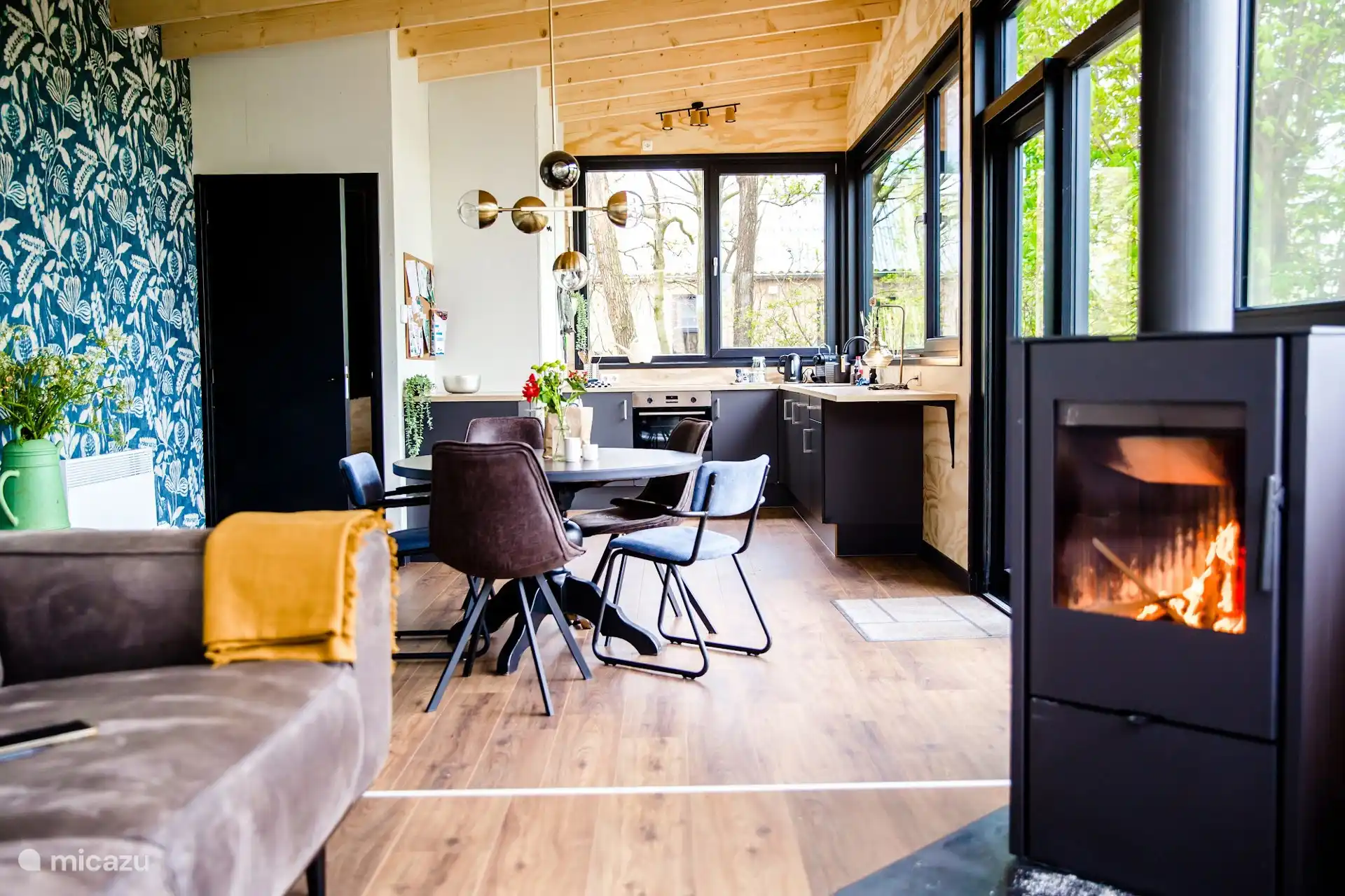 Sfeervolle woonkamer met houtkachel en comfortabele zithoek, ideaal om lekker weg te kruipen.