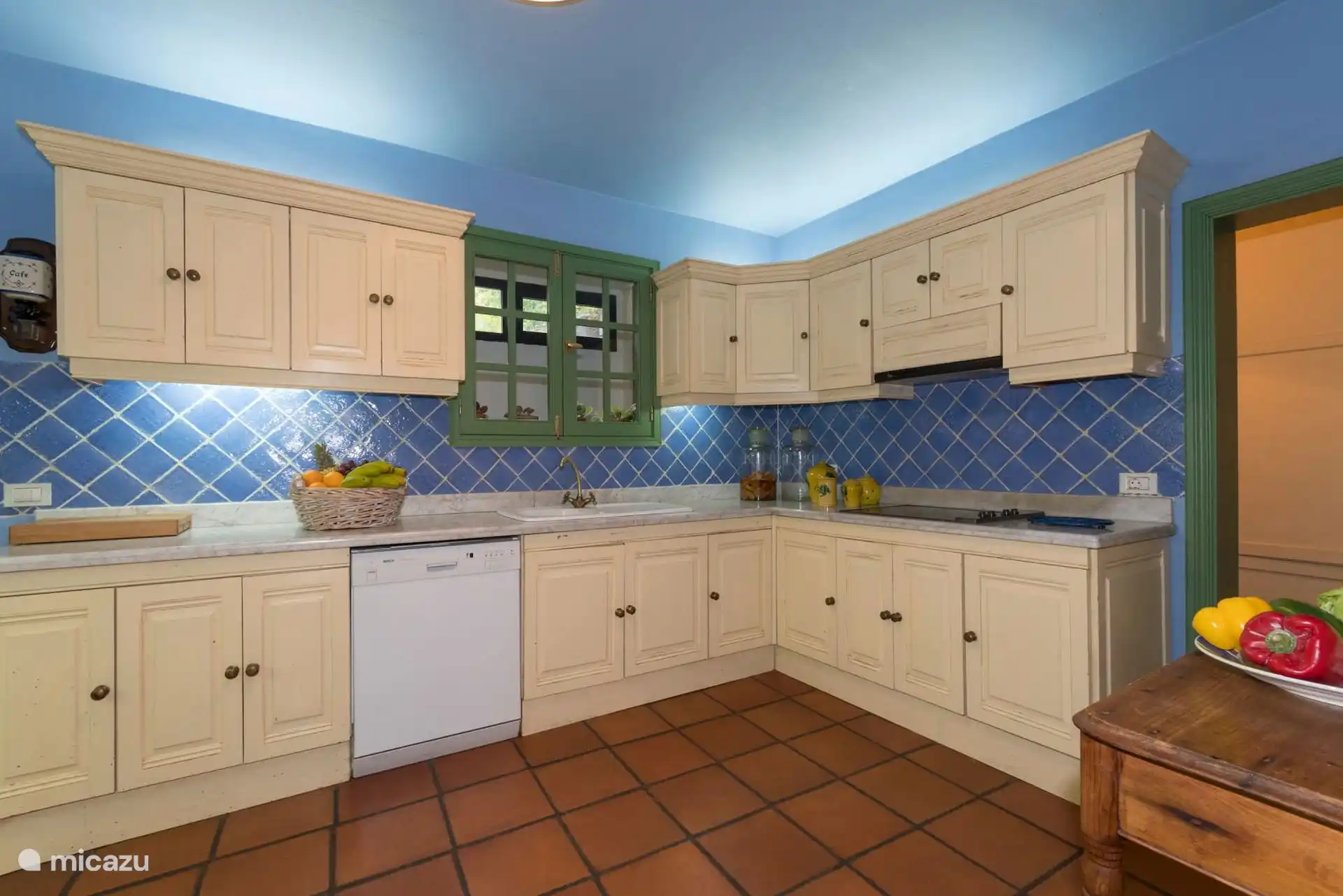 L-shaped kitchen with white furniture, dishwasher and plenty of worktop