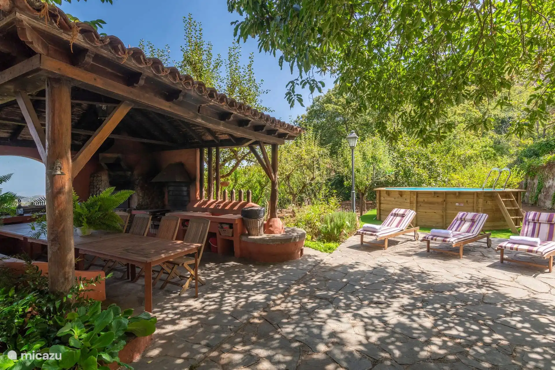 Patio with wooden pergola, outdoor dining area and sun loungers