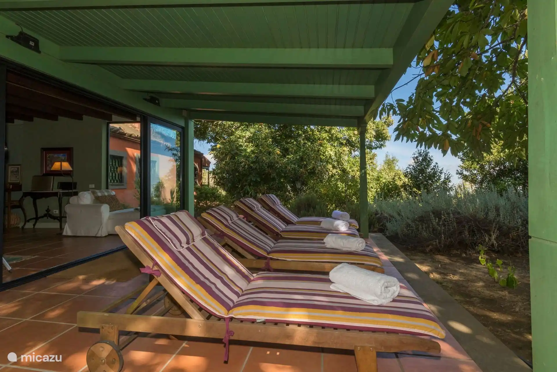 Porch with sun loungers next to the conservatory