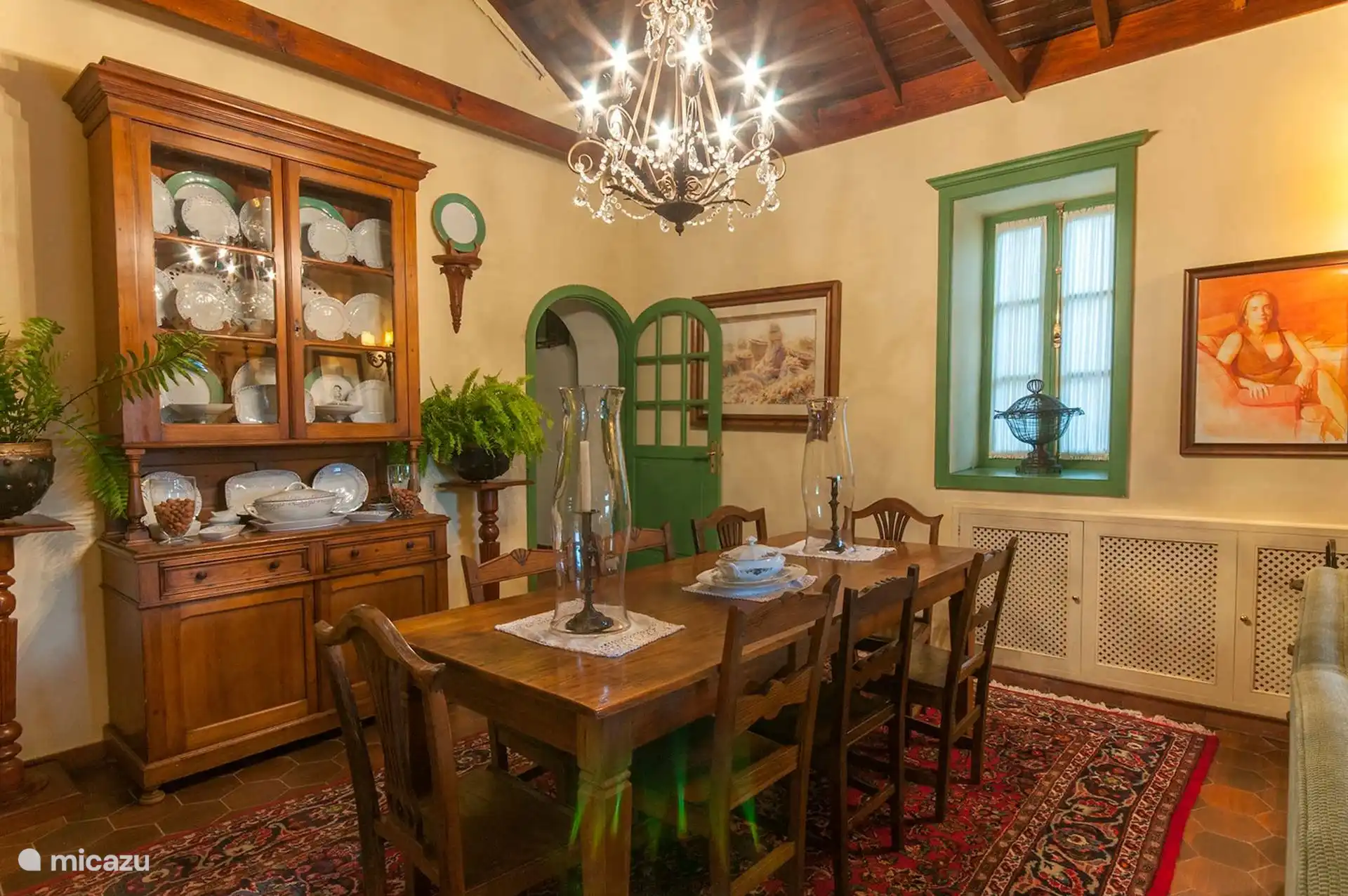 Dining room with wooden table, porcelain display case and chandelier