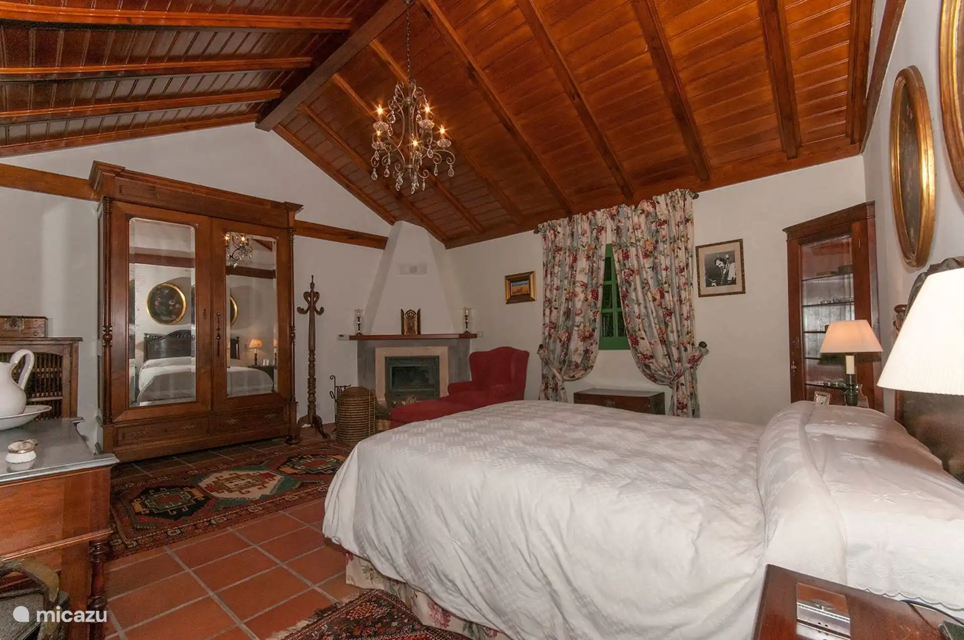 Double bedroom with fireplace, wooden ceiling and terracotta floor