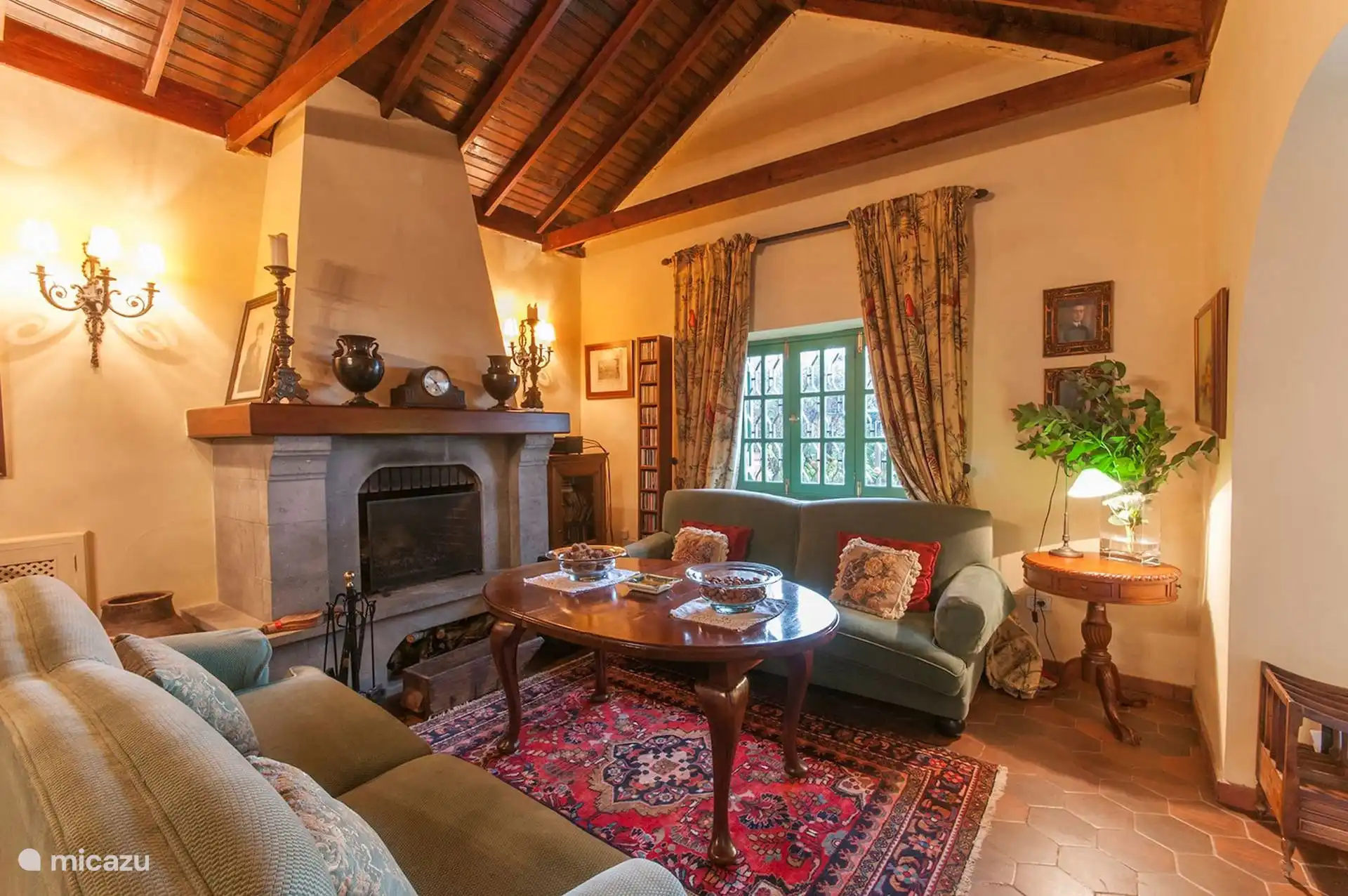 Second living room with stone fireplace and gabled wooden ceiling