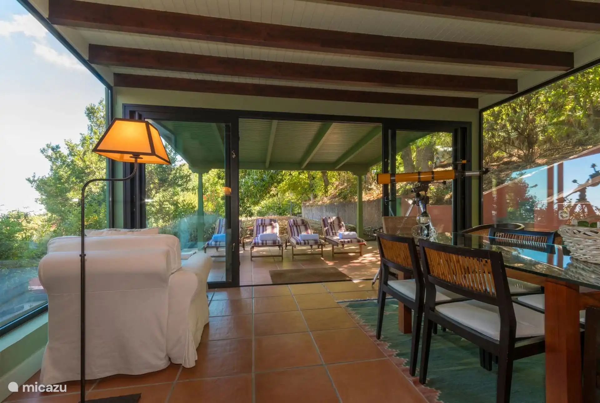 Glazed gallery with sofa and access to the covered terrace