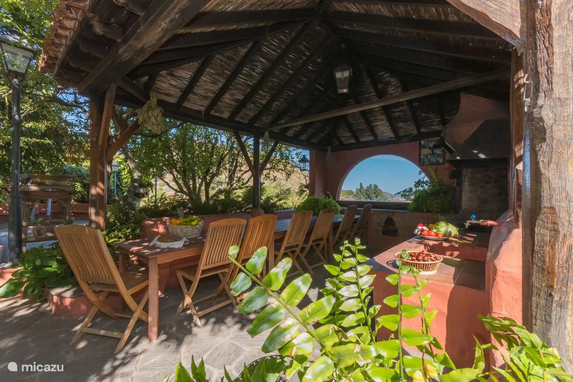 Hanging with table for eight and barbecue, surrounded by greenery