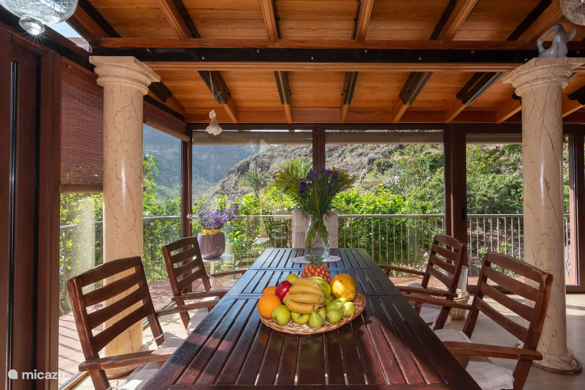 Lange houten tafel op het overdekte terras, met ruimte voor het hele huis.