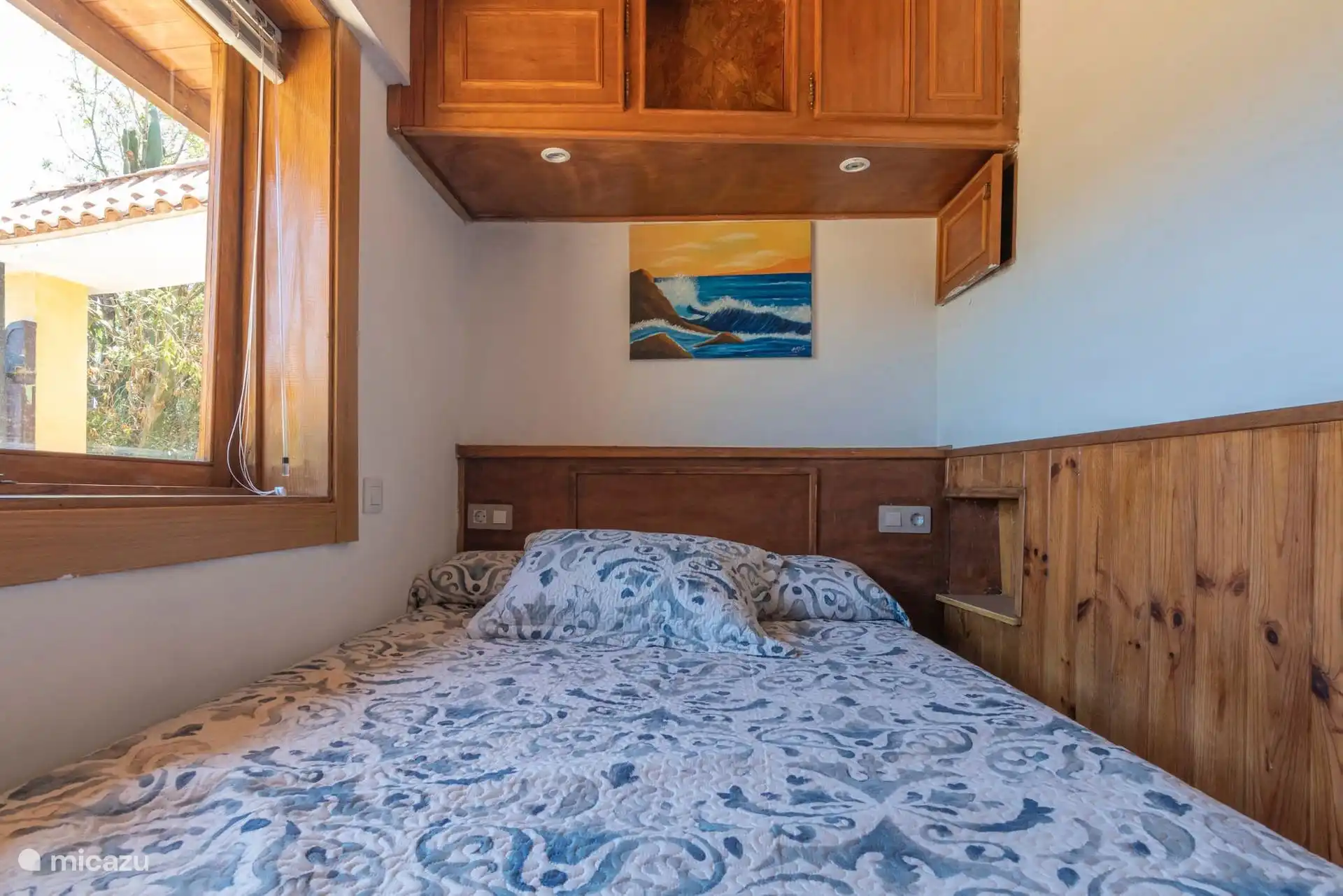 Tweede slaapkamer met tweepersoonsbed en houten meubels.