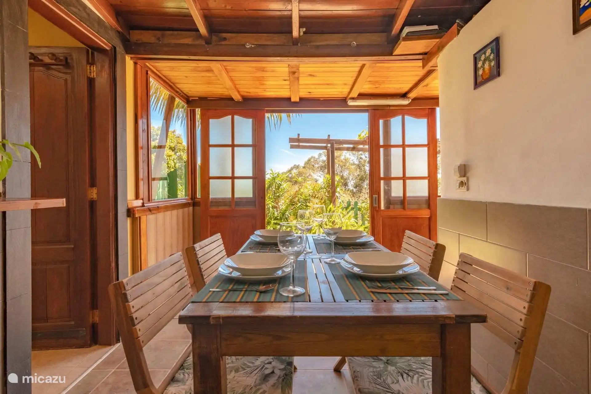 Eetkamer met deuren open naar de tuin.