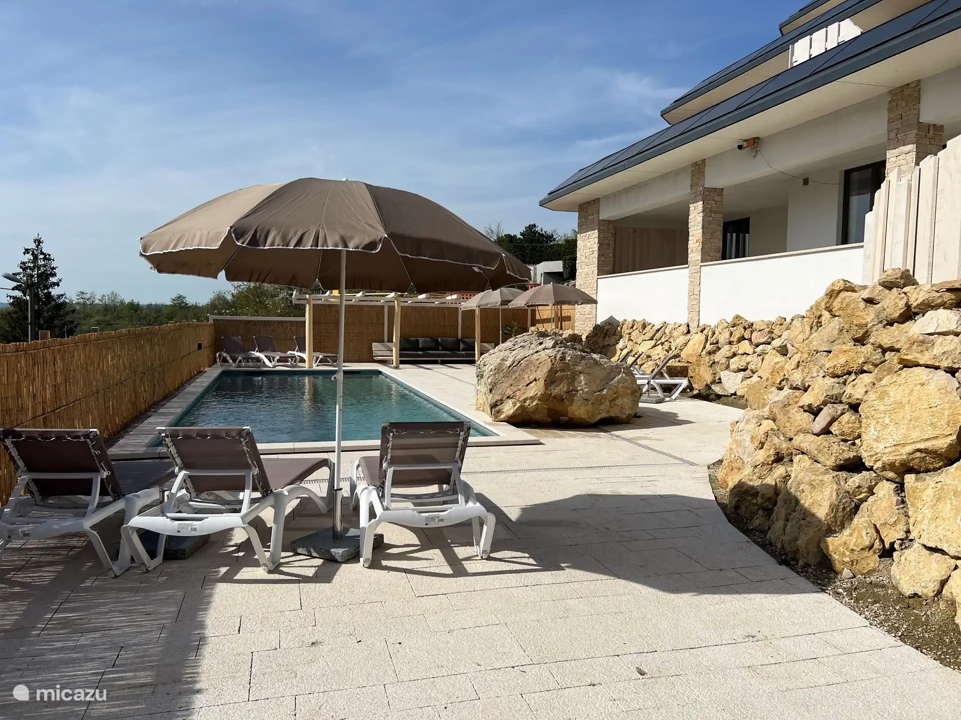 The swimming pool with terrace and sunbeds