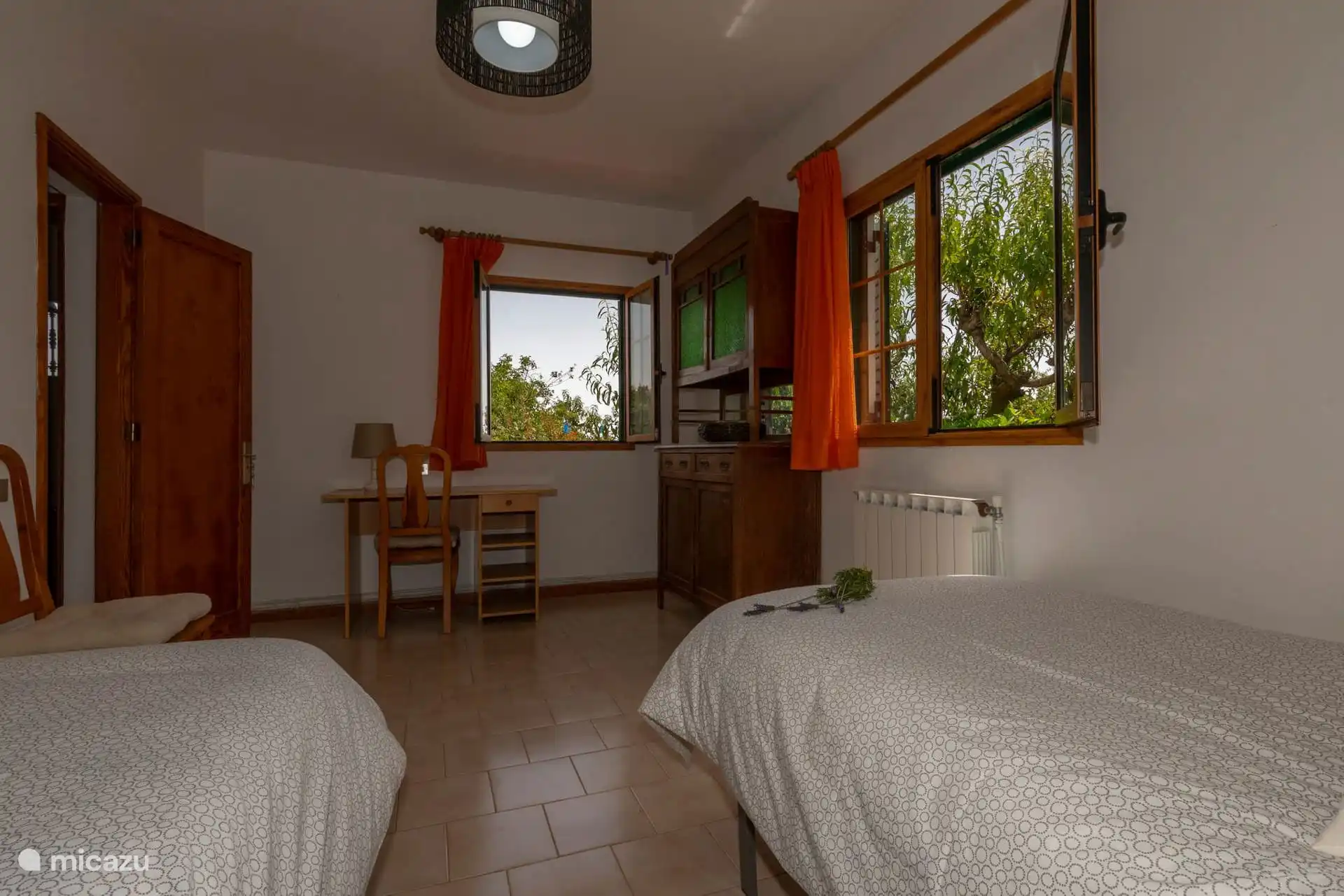 Vista del dormitorio con escritorio junto a la ventana.