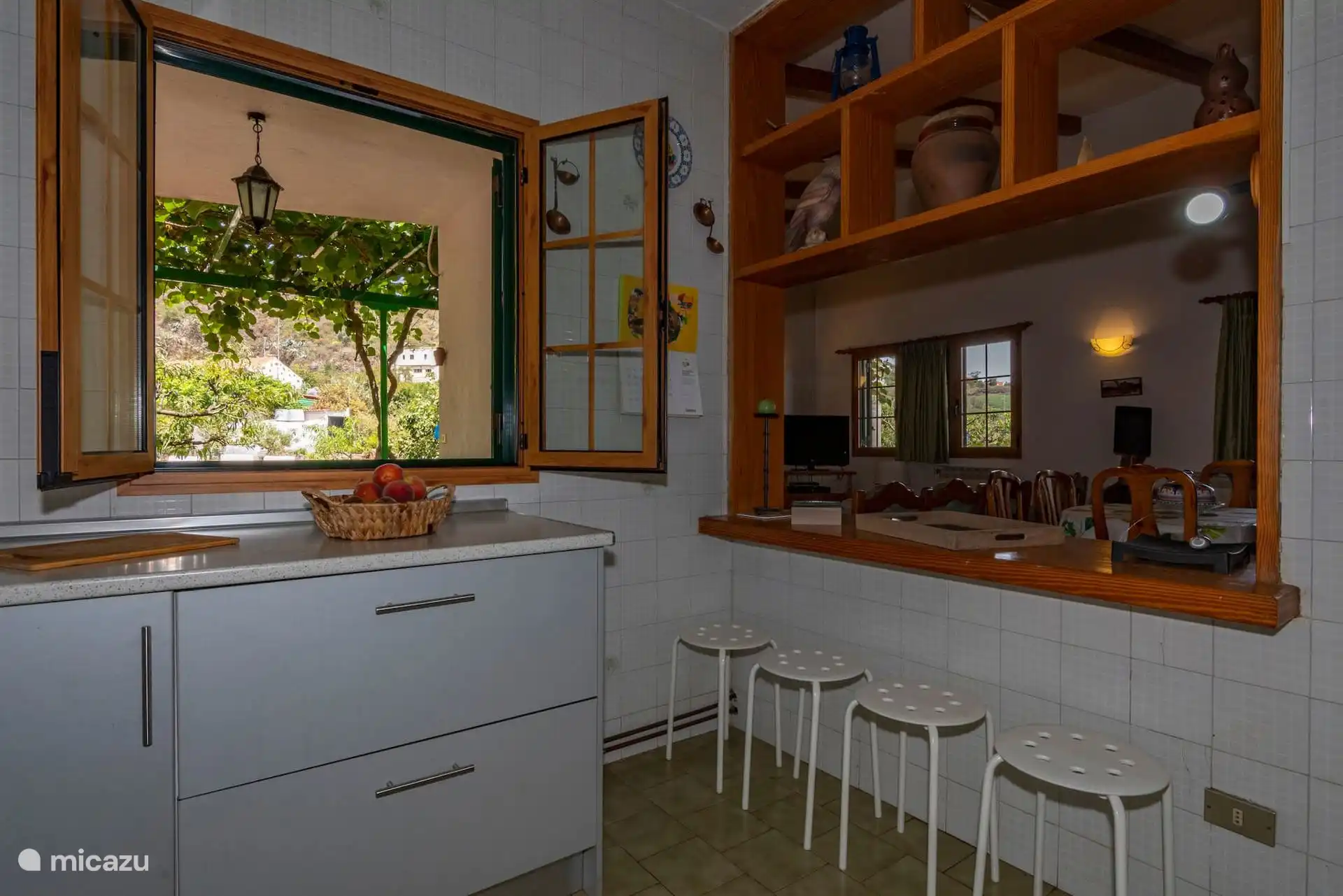 Otra vista de la cocina, con la barra y las banquetas.
