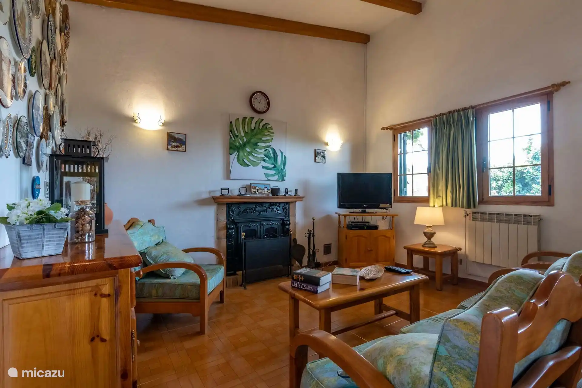 Salón con chimenea, butacas y televisión.