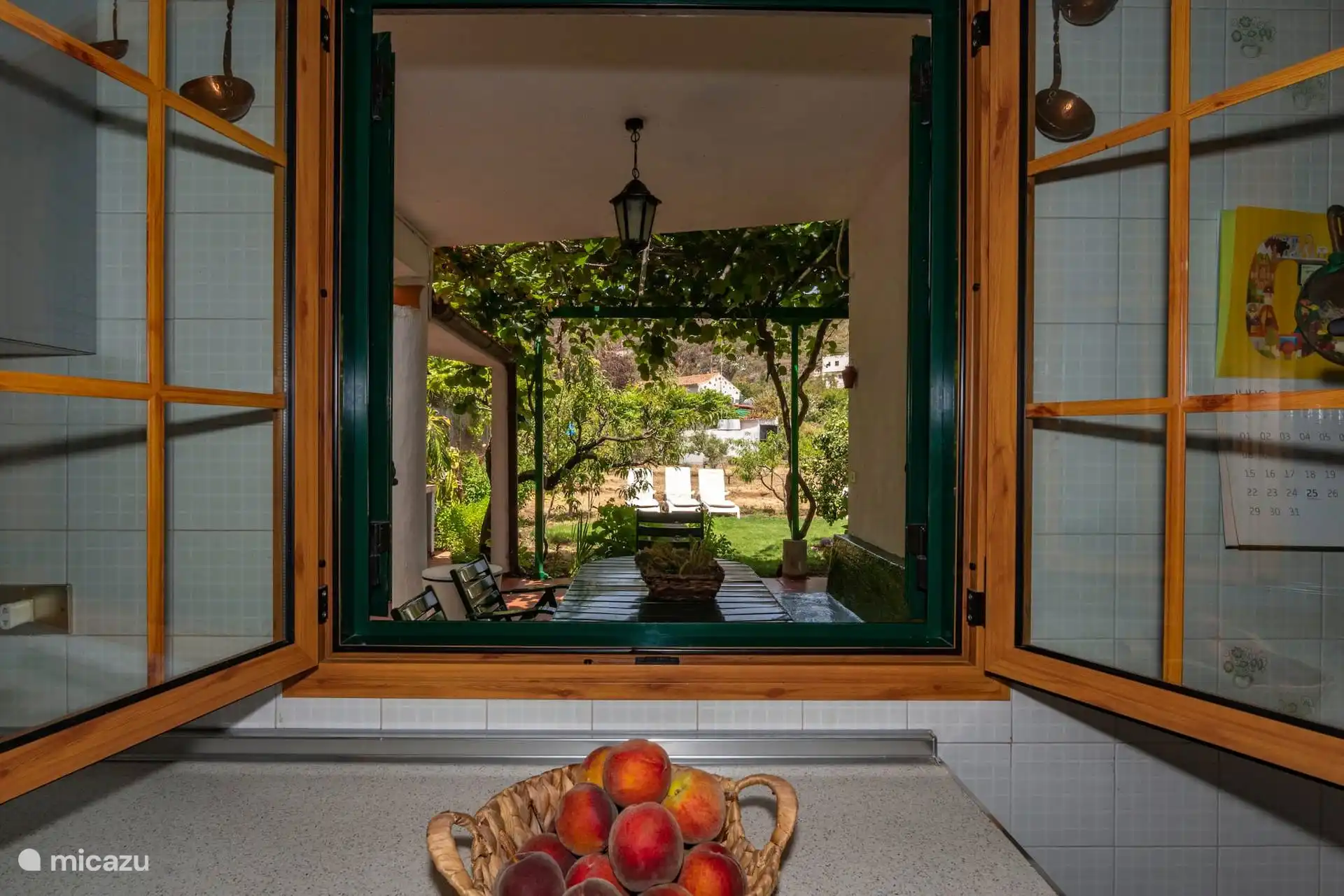Ventana de la cocina abierta al parral y al jardín.