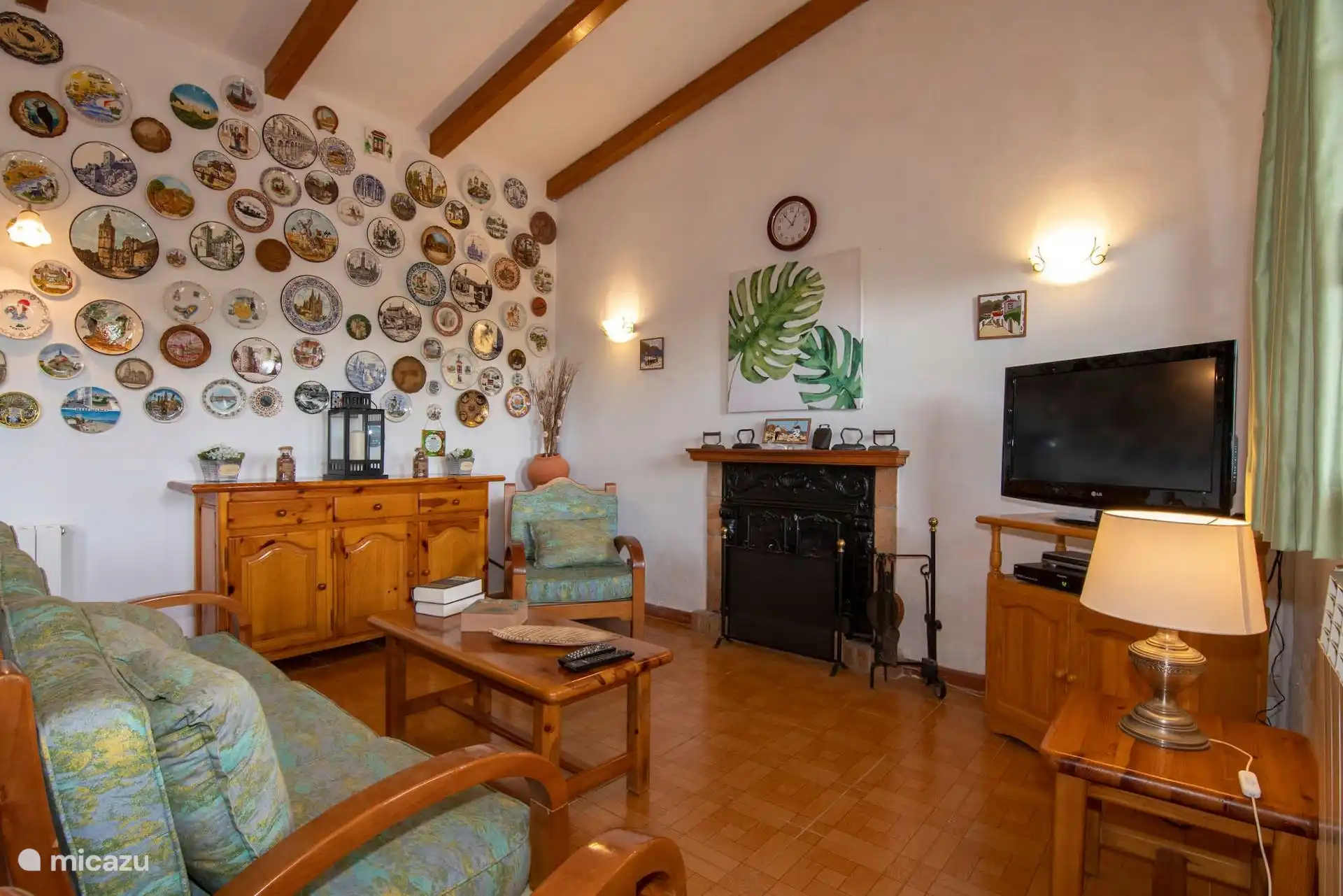 Salón amplio con sofás, chimenea y la colección de platos.