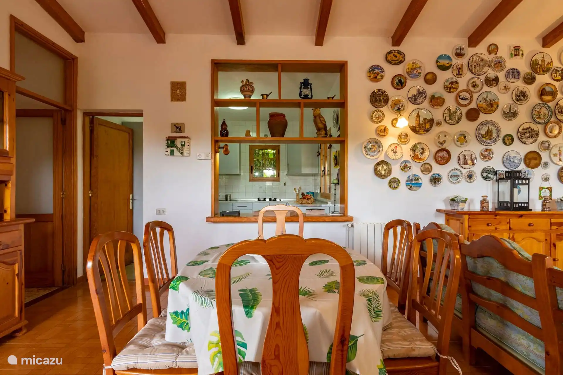 Comedor con mesa para seis y la colección de platos en la pared.
