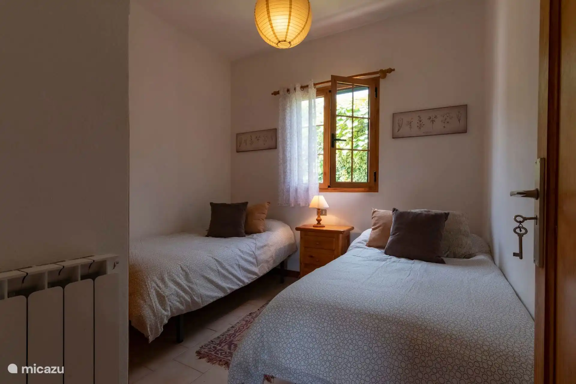 Dormitorio con dos camas individuales y ventana al exterior.