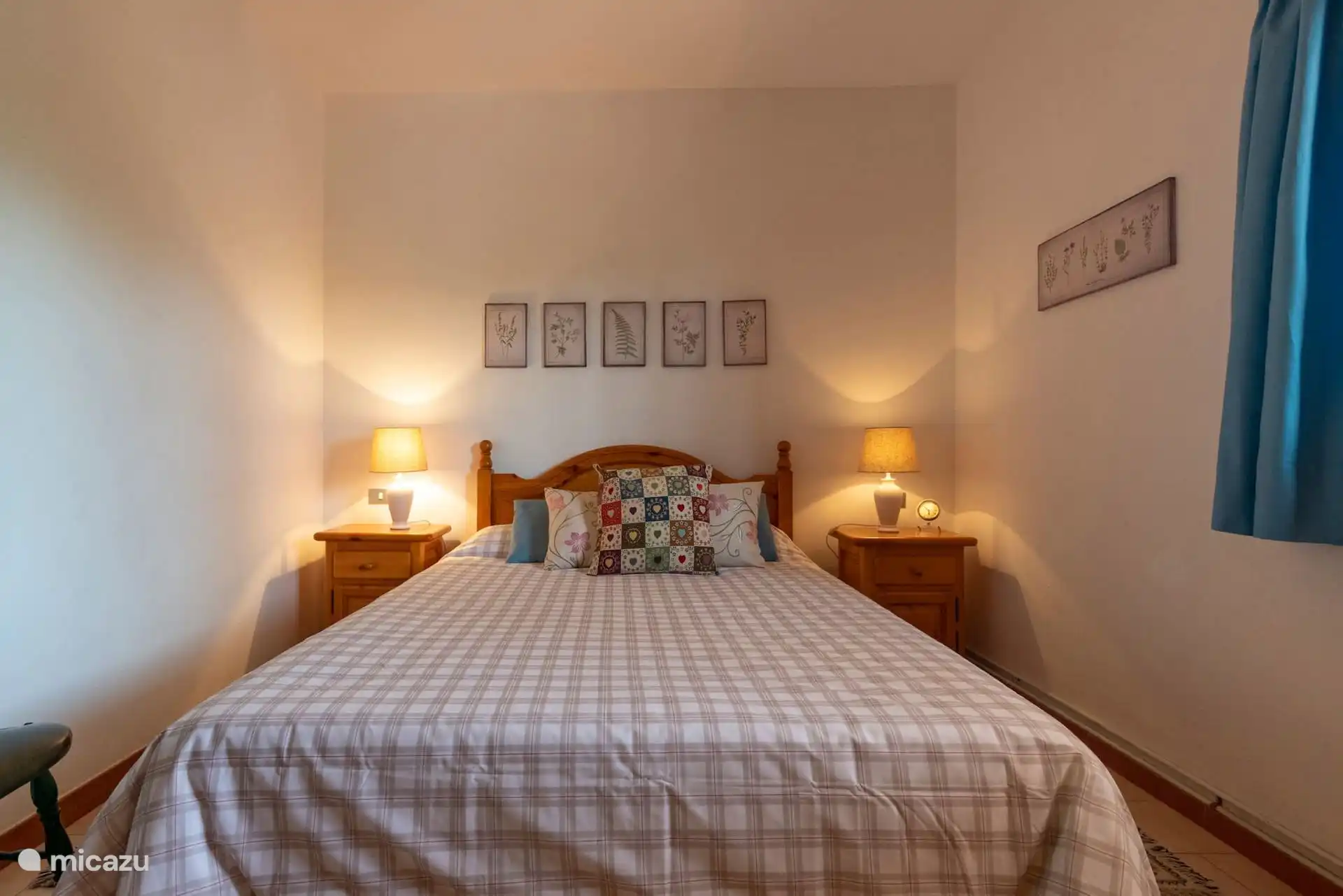 Dormitorio de matrimonio con lámpara de papel y cortinas.