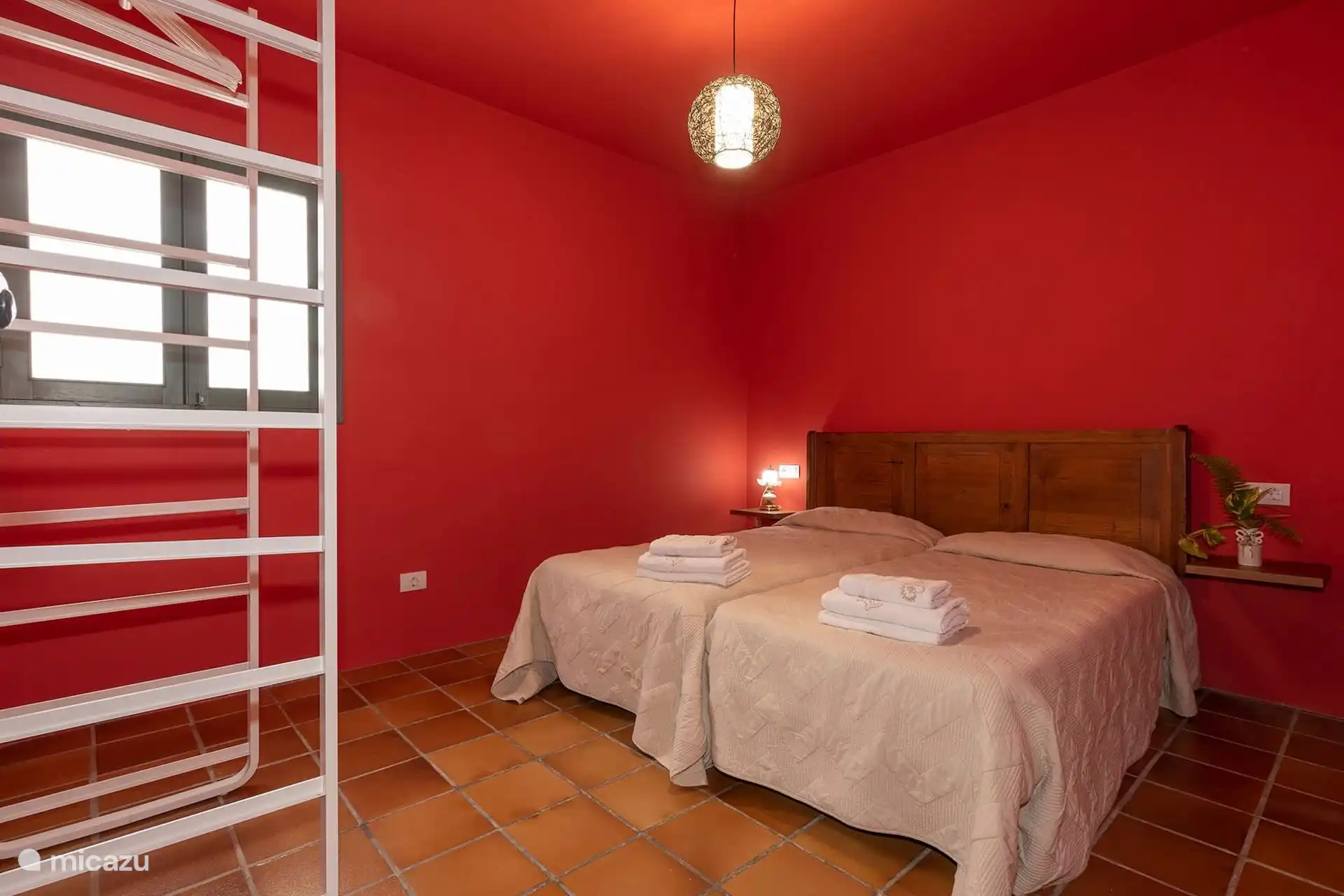 Dormitorio con dos camas individuales juntas y toallas preparadas.