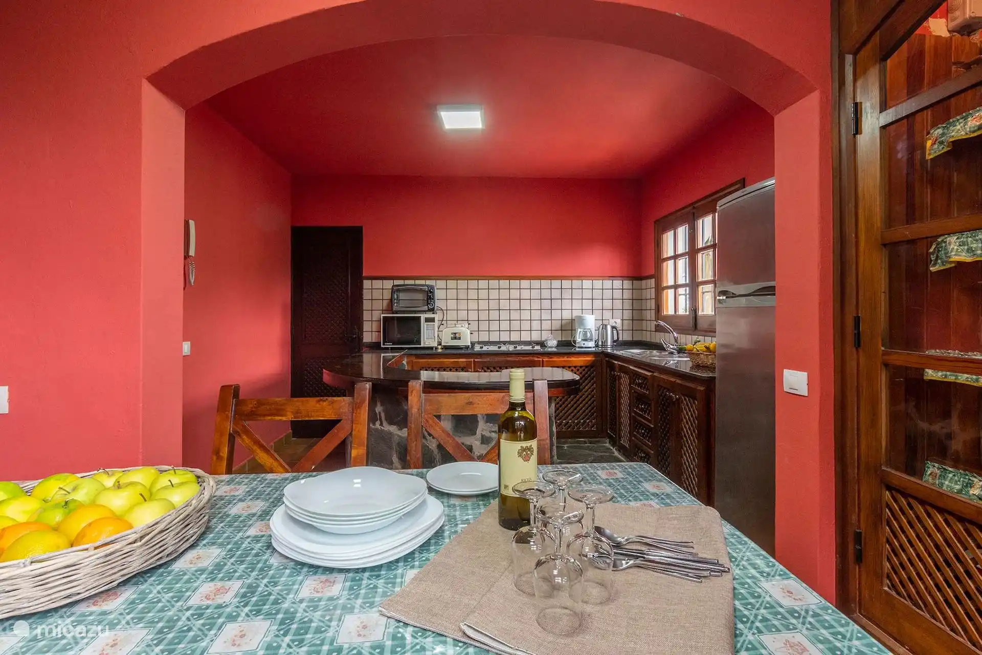 Cocina con barra de piedra, nevera grande y microondas.