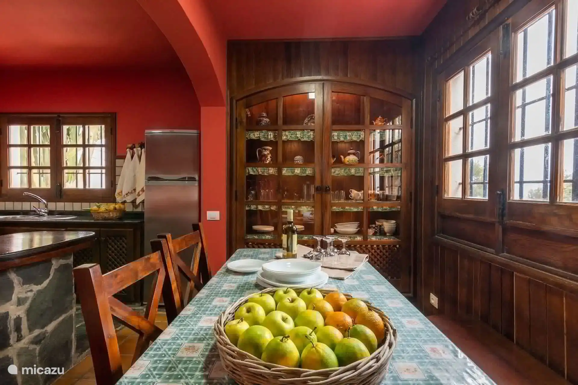 Comedor junto a la cocina, con vitrina canaria y mesa puesta.