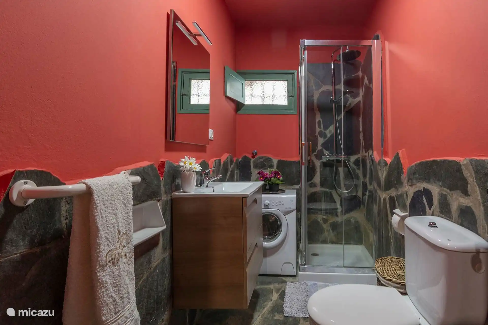 Segundo baño con ducha, lavadora y lavabo.