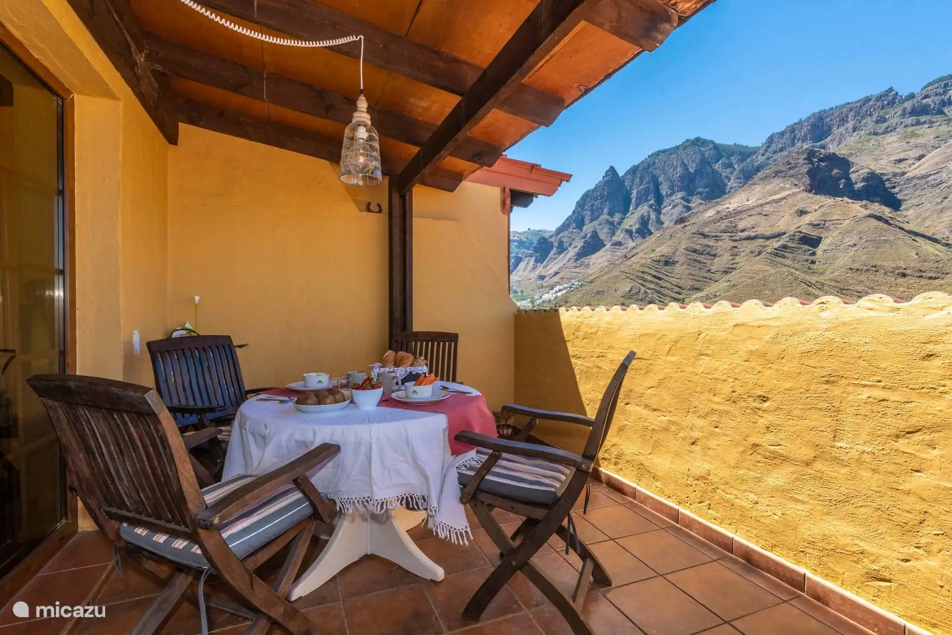 Mesa preparada en la terraza, con las montañas del valle enfrente.