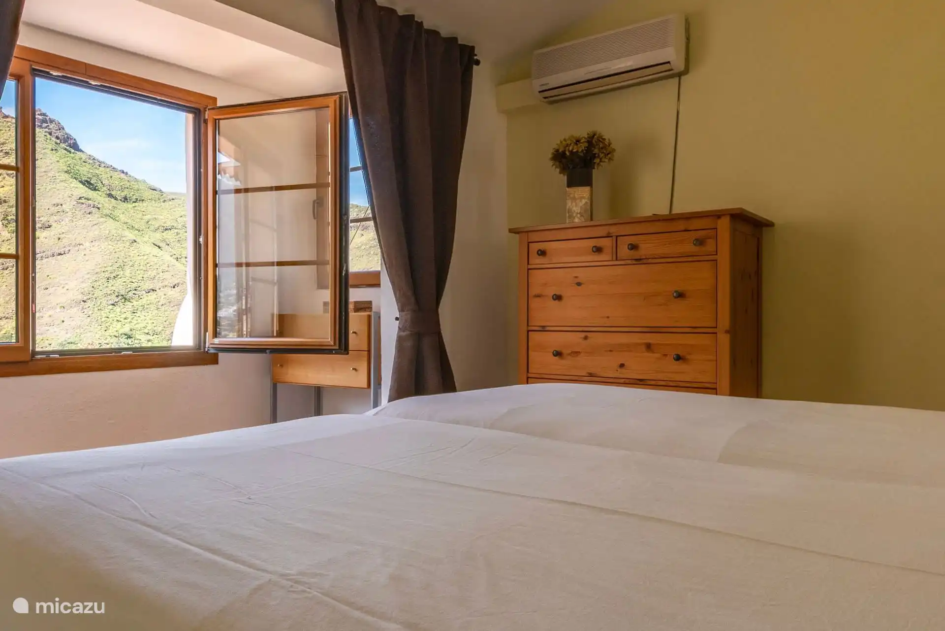 Vista del dormitorio con la ventana al valle y aire acondicionado.