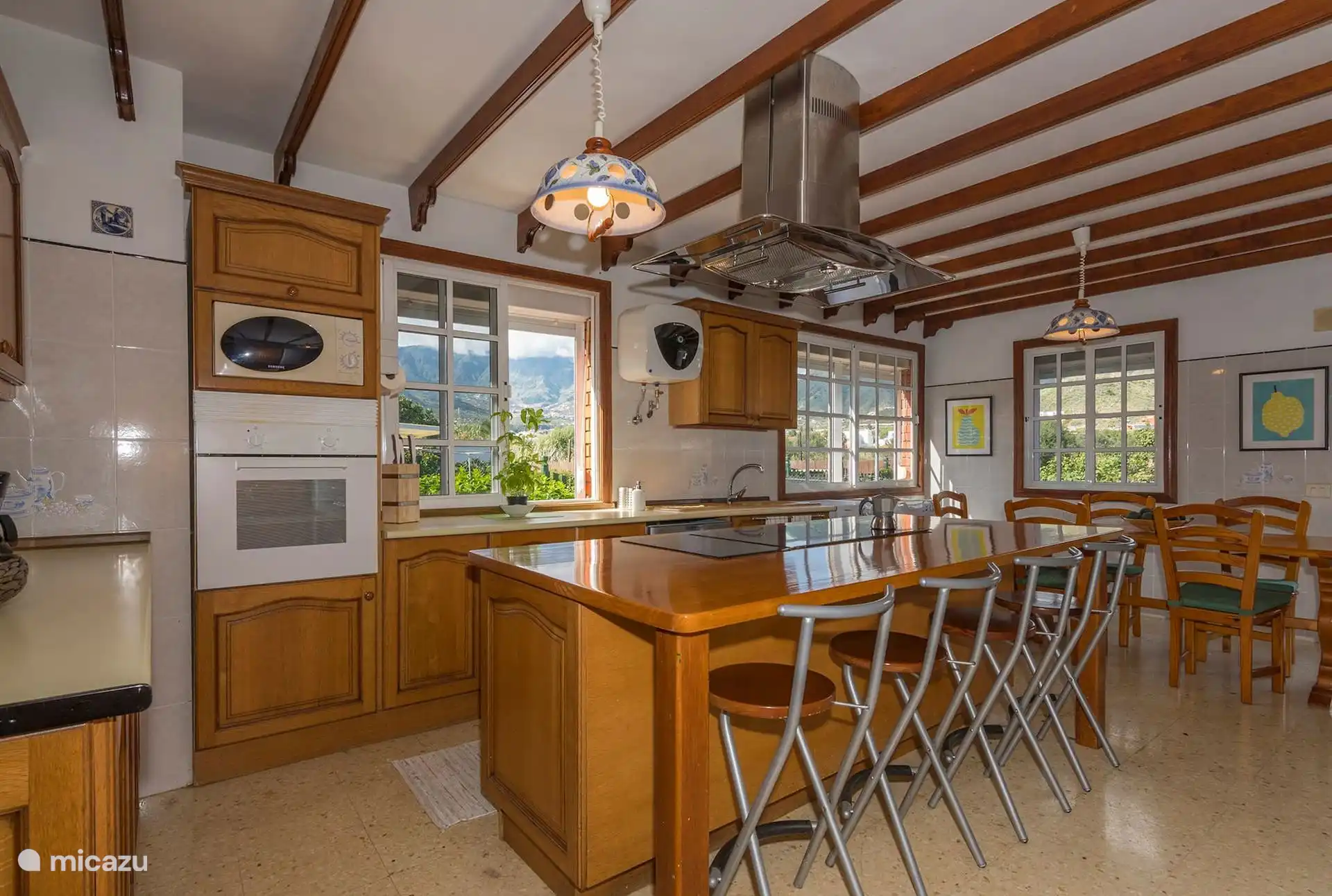 Otra vista de la cocina, con la isla y el comedor al fondo.