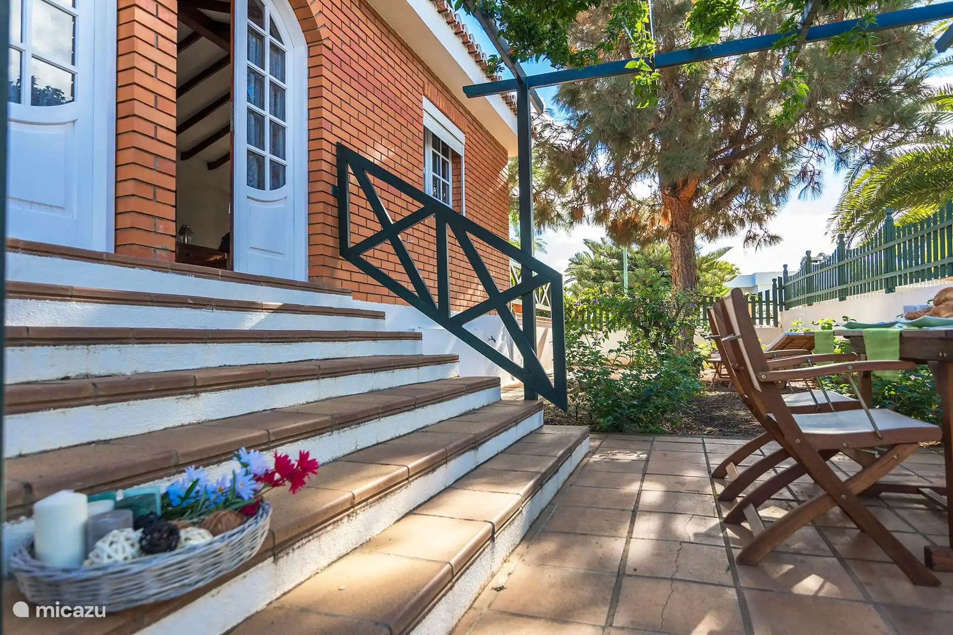 Mesa puesta en el patio, bajo la pérgola de la entrada.