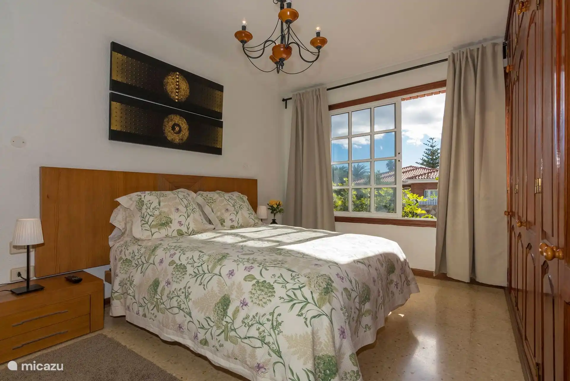 Dormitorio con cama de matrimonio y ventana con vistas a las medianías.