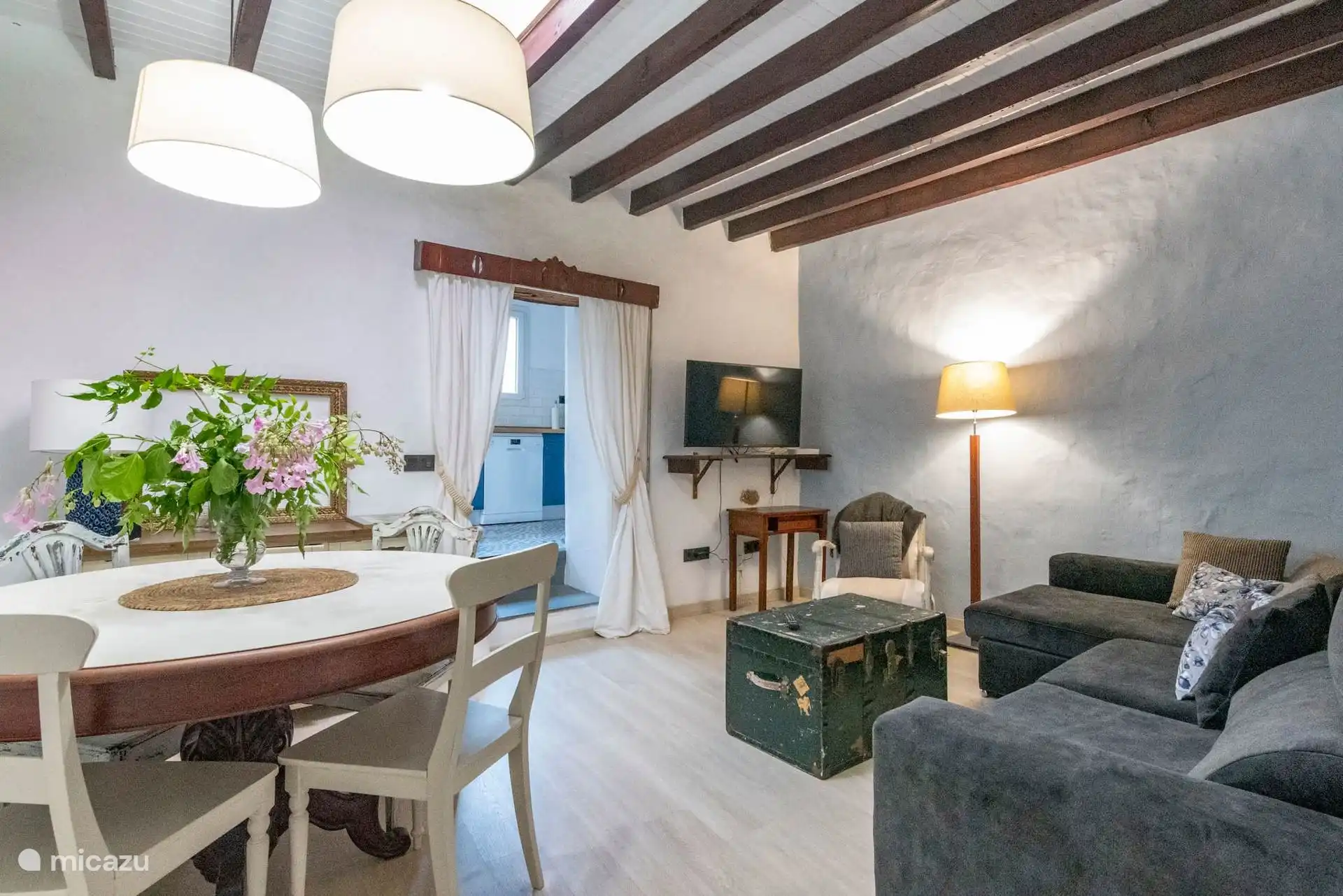 Comedor y salón bajo las vigas de madera del techo.