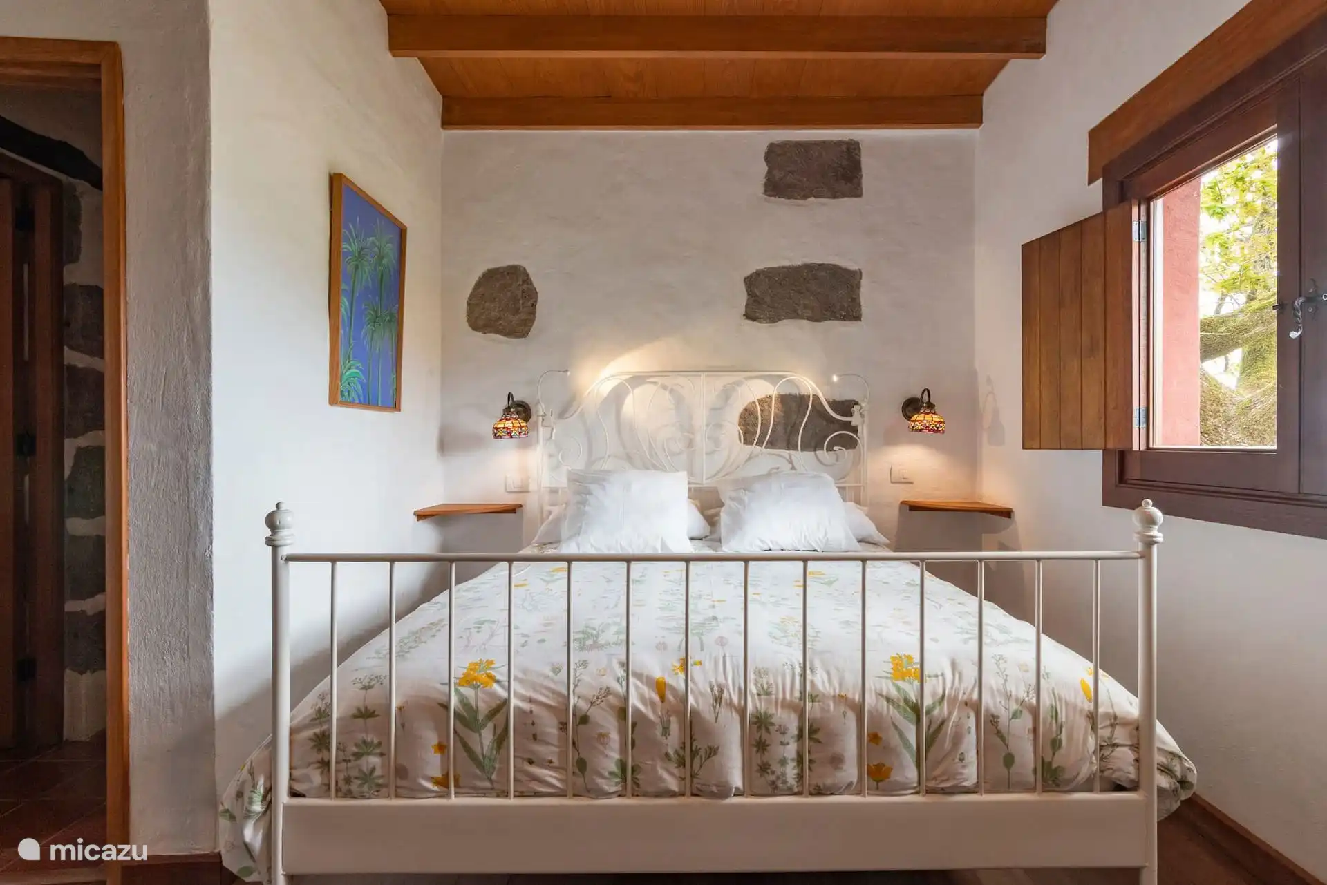 Otra vista del dormitorio, con las mesitas y los apliques.