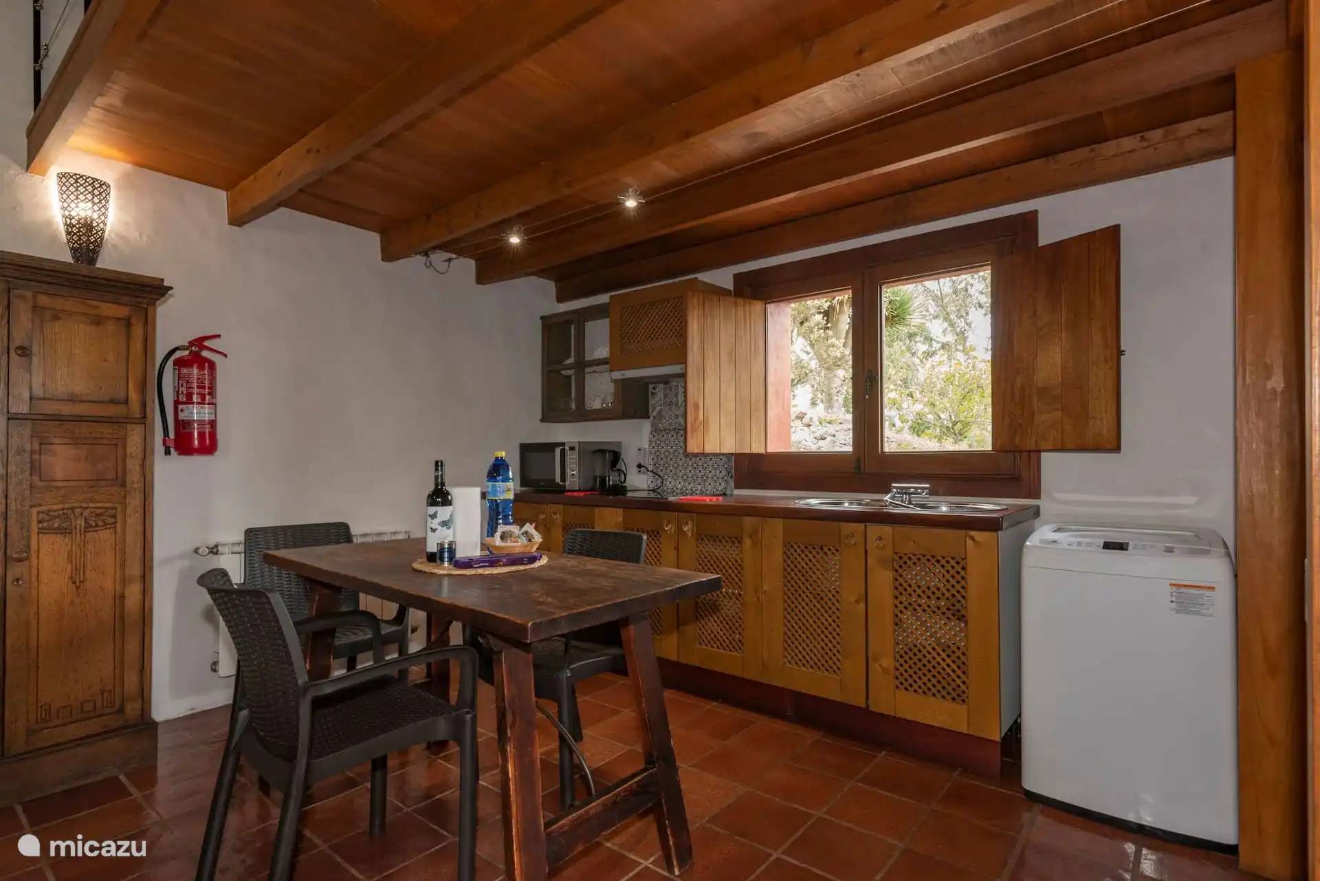 Cocina con lavadora, lavavajillas y mesa de desayuno.