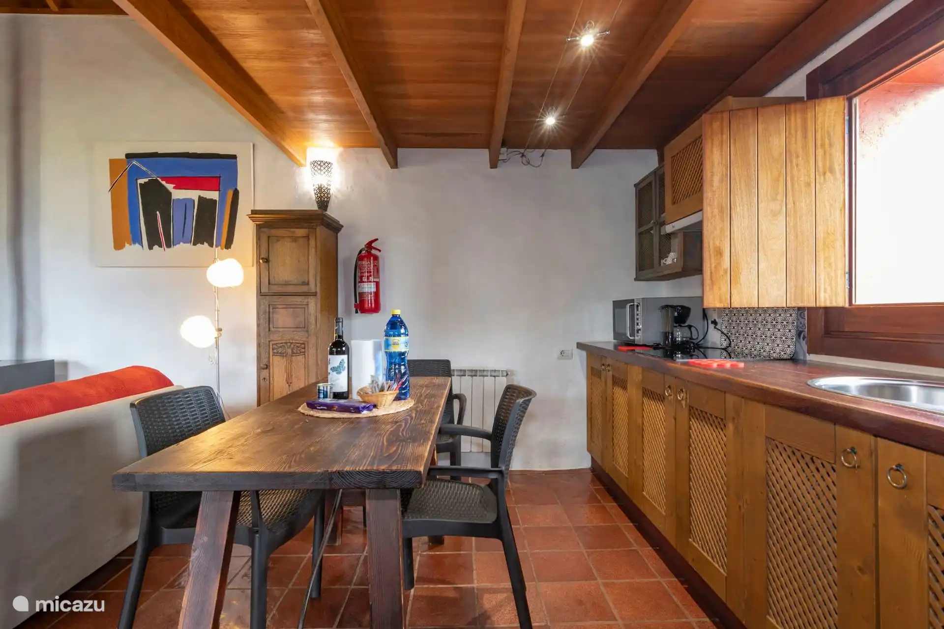 Cocina abierta al salón, con muebles de madera.