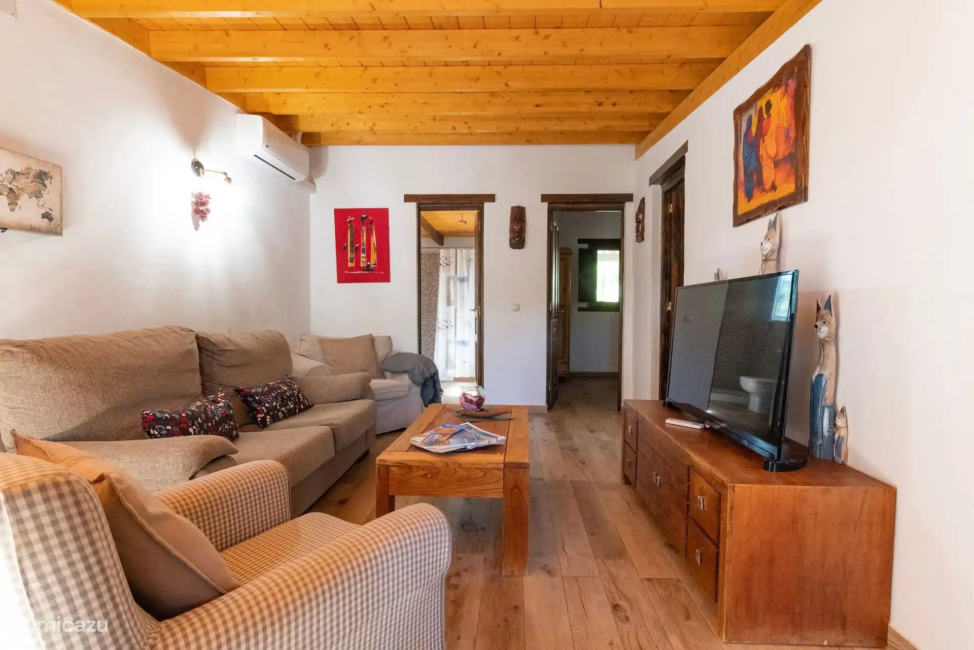 Wohnzimmer mit Sofas, Fernseher und Klimaanlage.