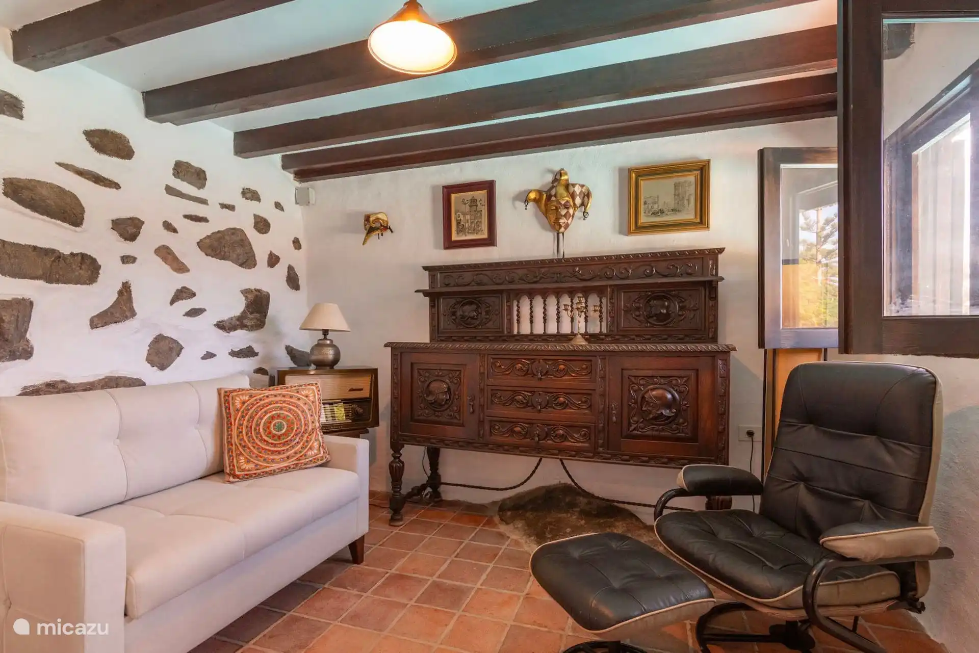 Rincón de estar con butaca reclinable y cómoda de madera.