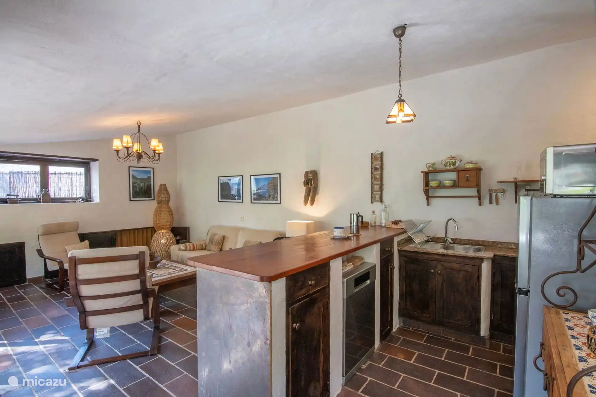 Salón comedor con la barra de la cocina al fondo.