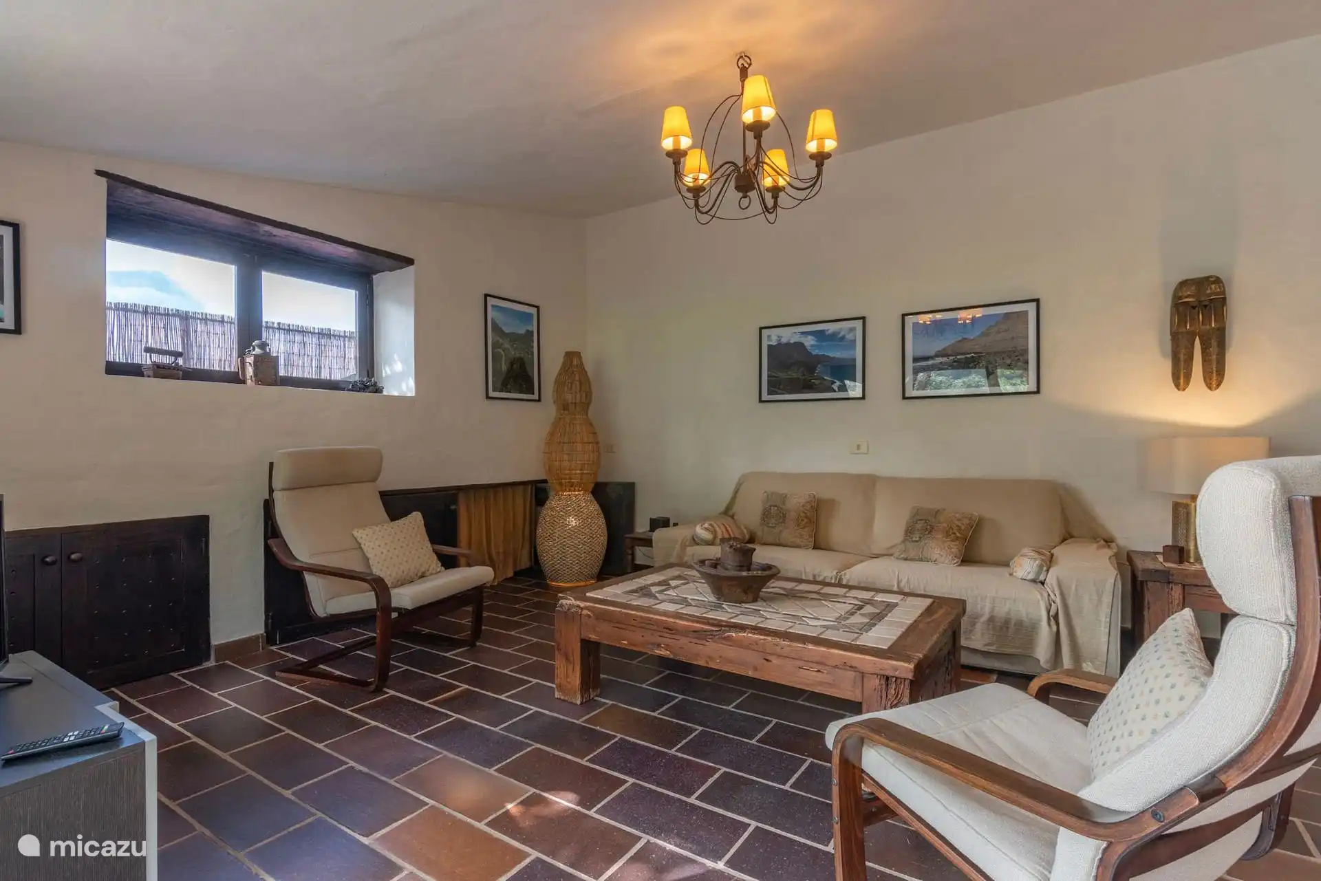 Otra vista del salón, con la chimenea de leña y las butacas.