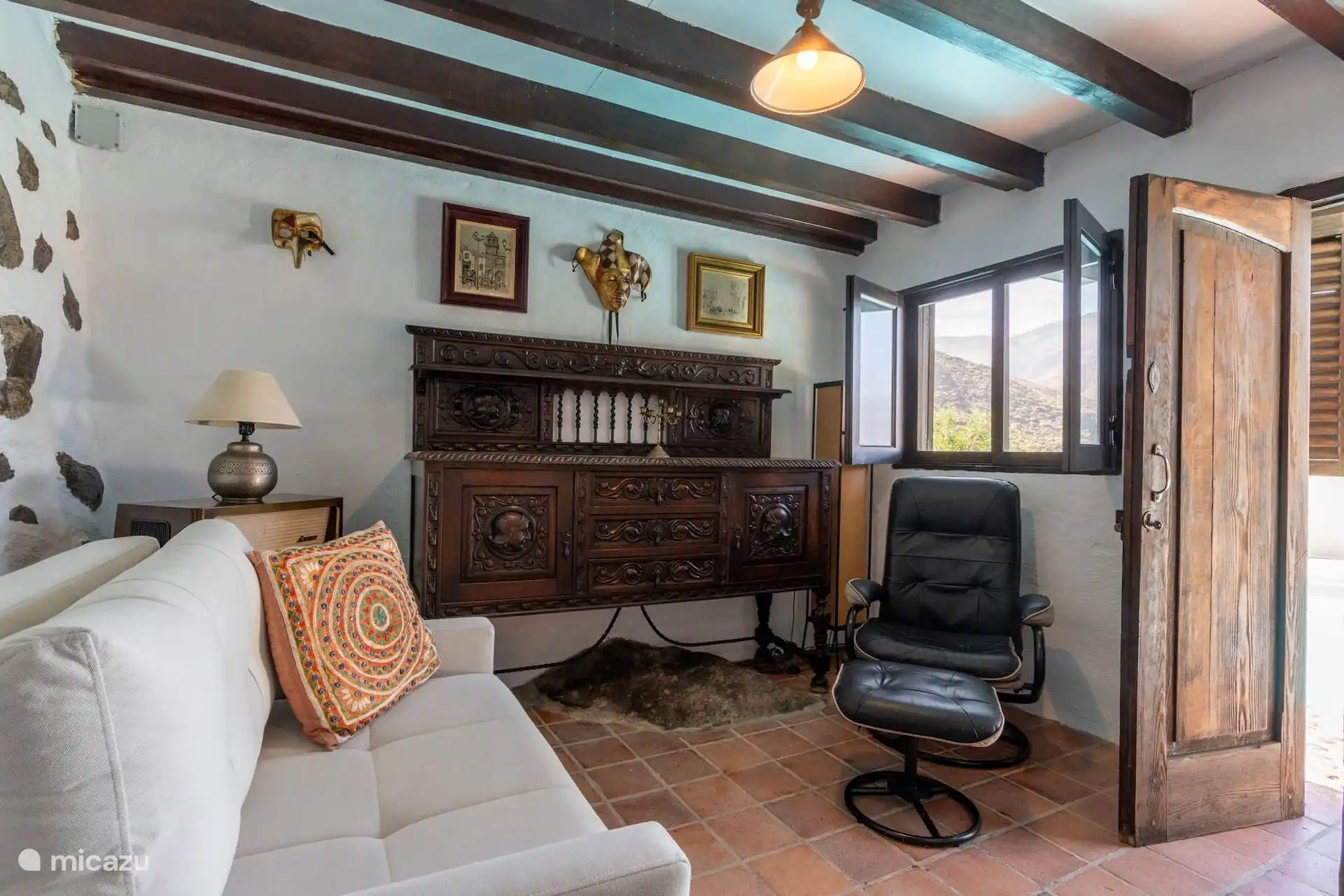 Zona de estar del dormitorio, con sofá y cómoda canaria.