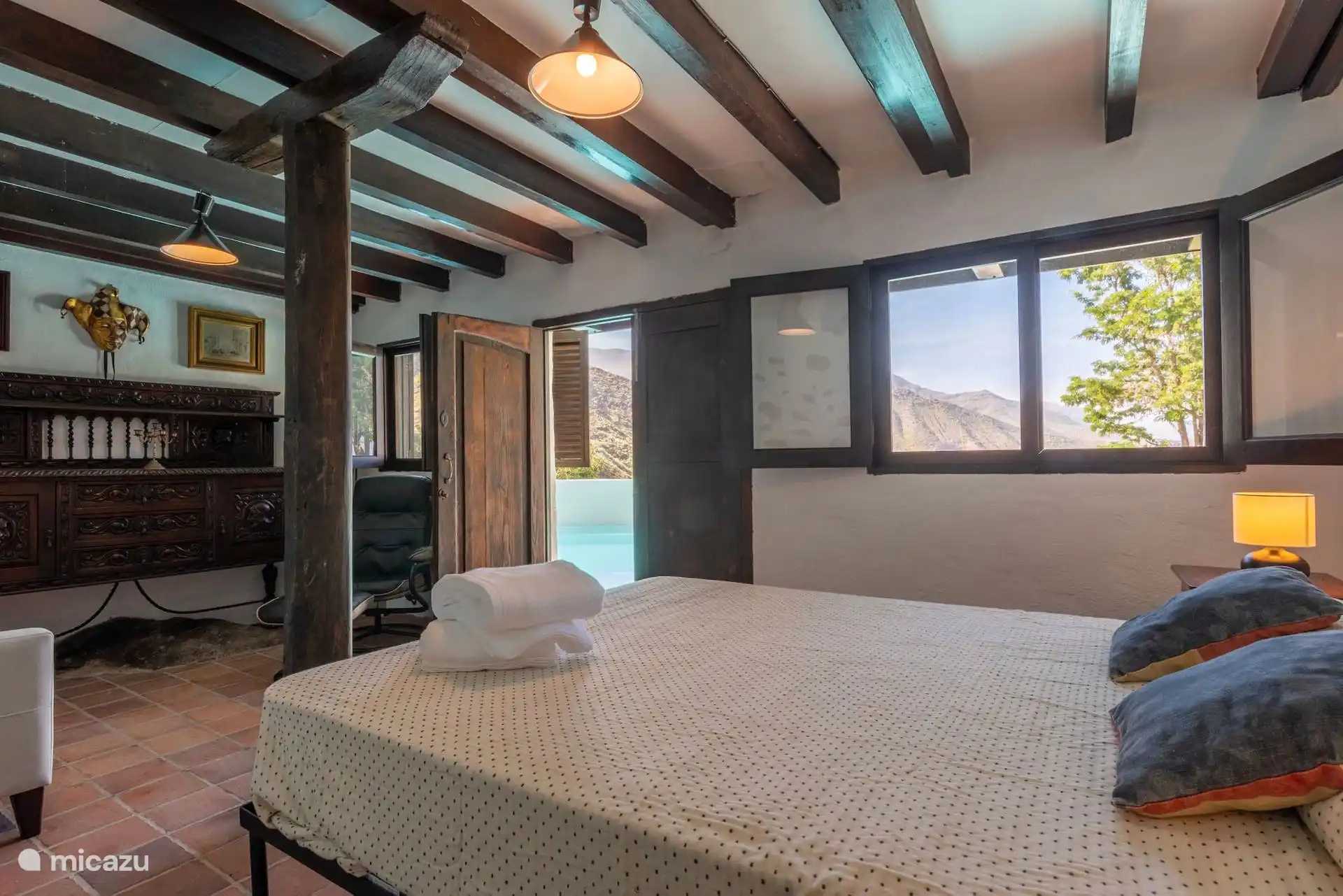 Vista del dormitorio con sofá cama y salida a la terraza.