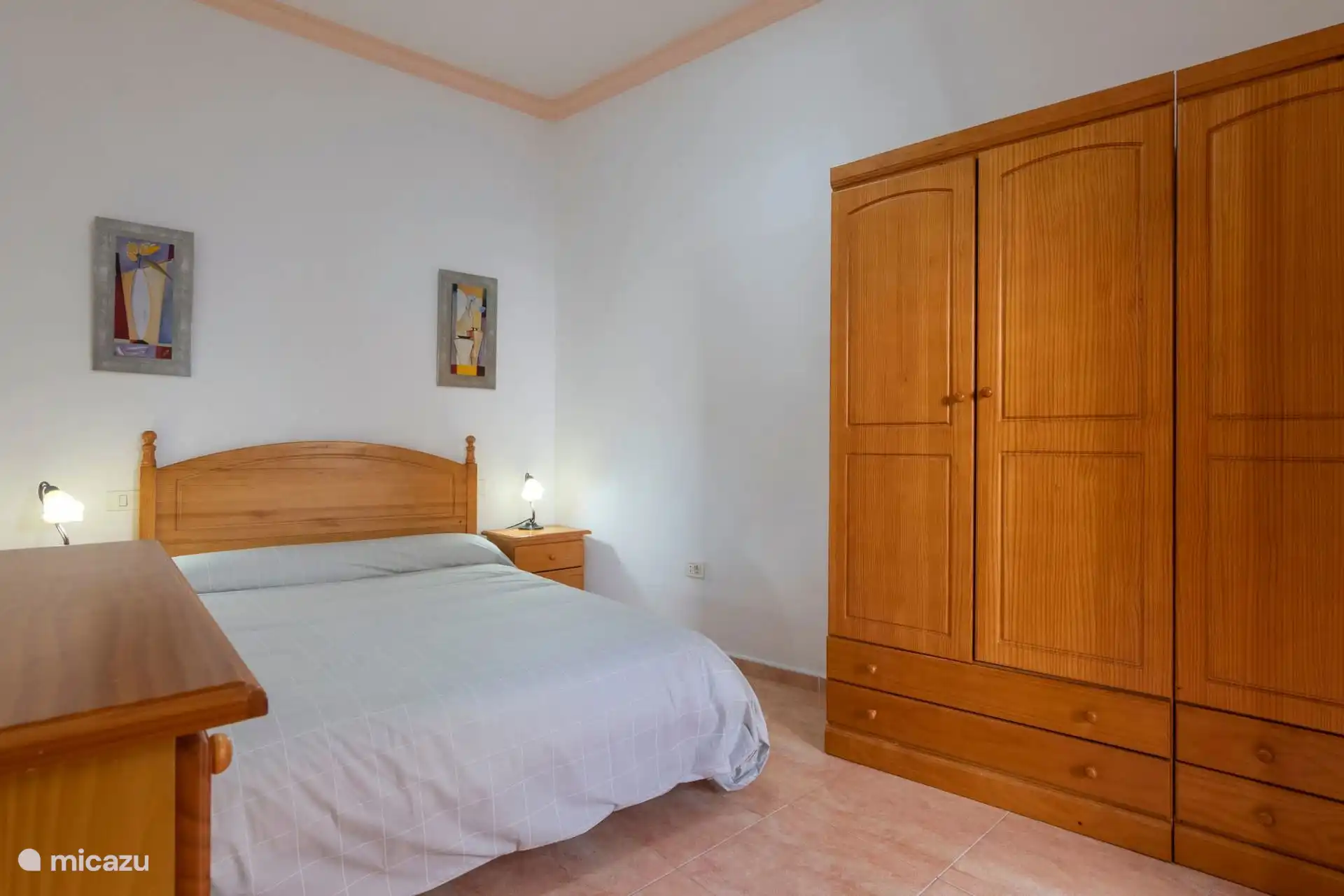 Hoofdslaapkamer met ingebouwde houten kast.