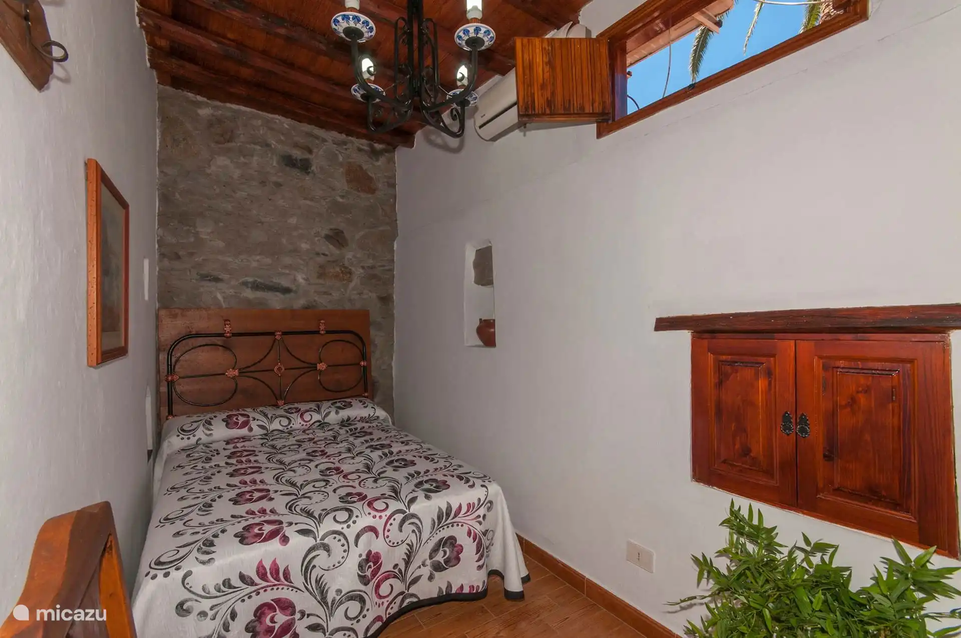 Zweites Schlafzimmer mit Doppelbett unter Balkendecke.