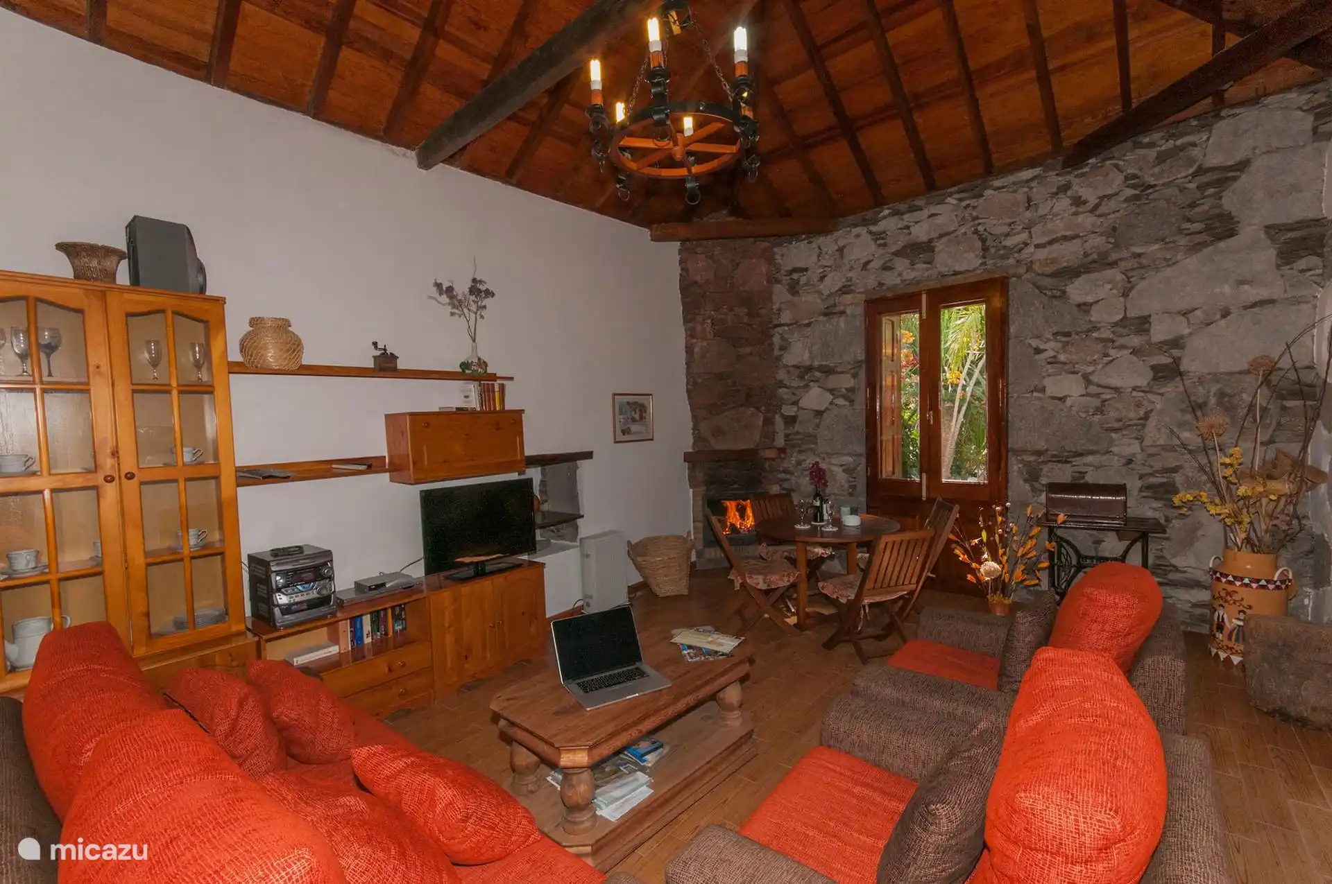 Wohnzimmer mit Kamin und freiliegender Steinwand.