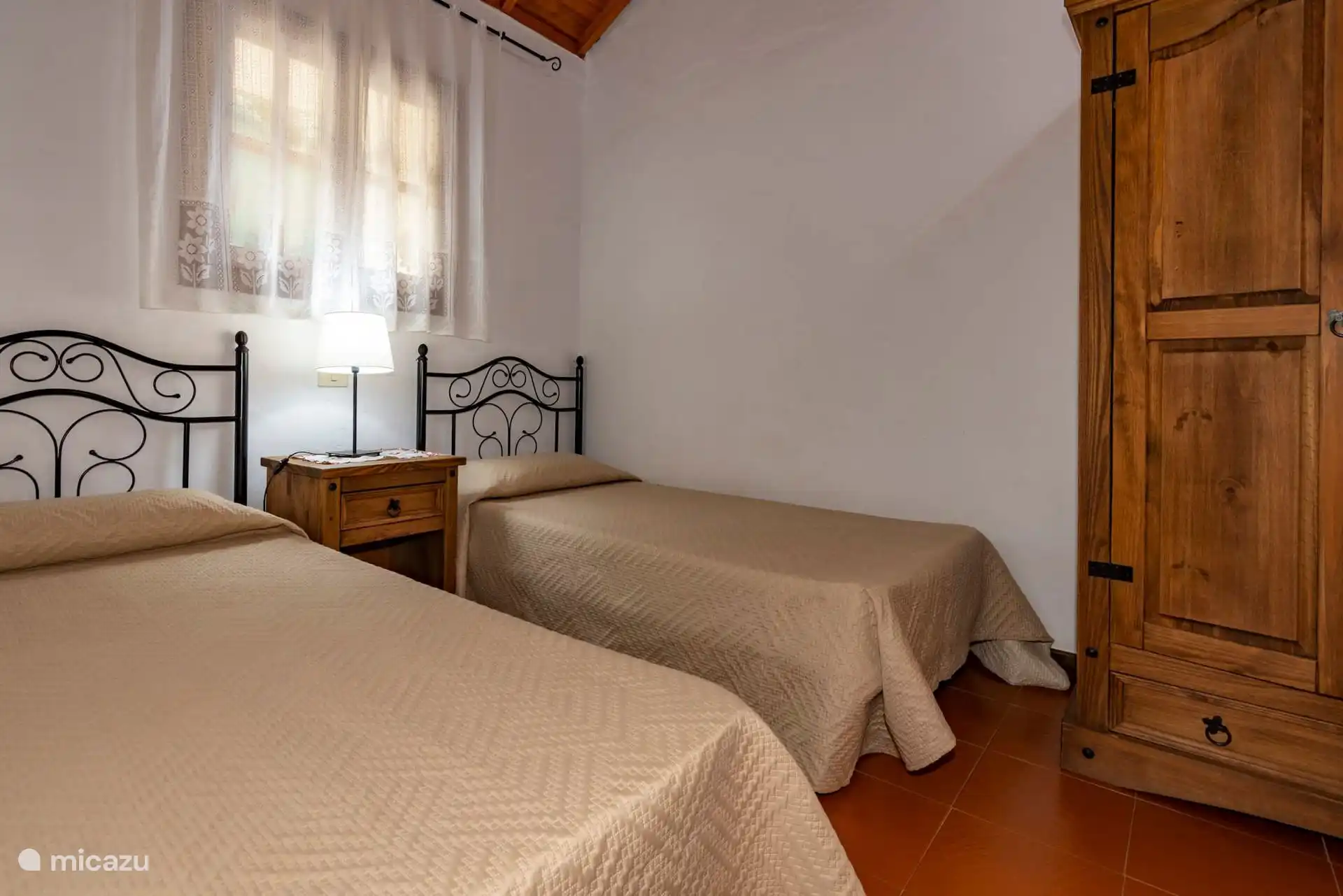 Ein weiterer Blick auf das Zwillingsschlafzimmer mit Holzkleiderschrank.